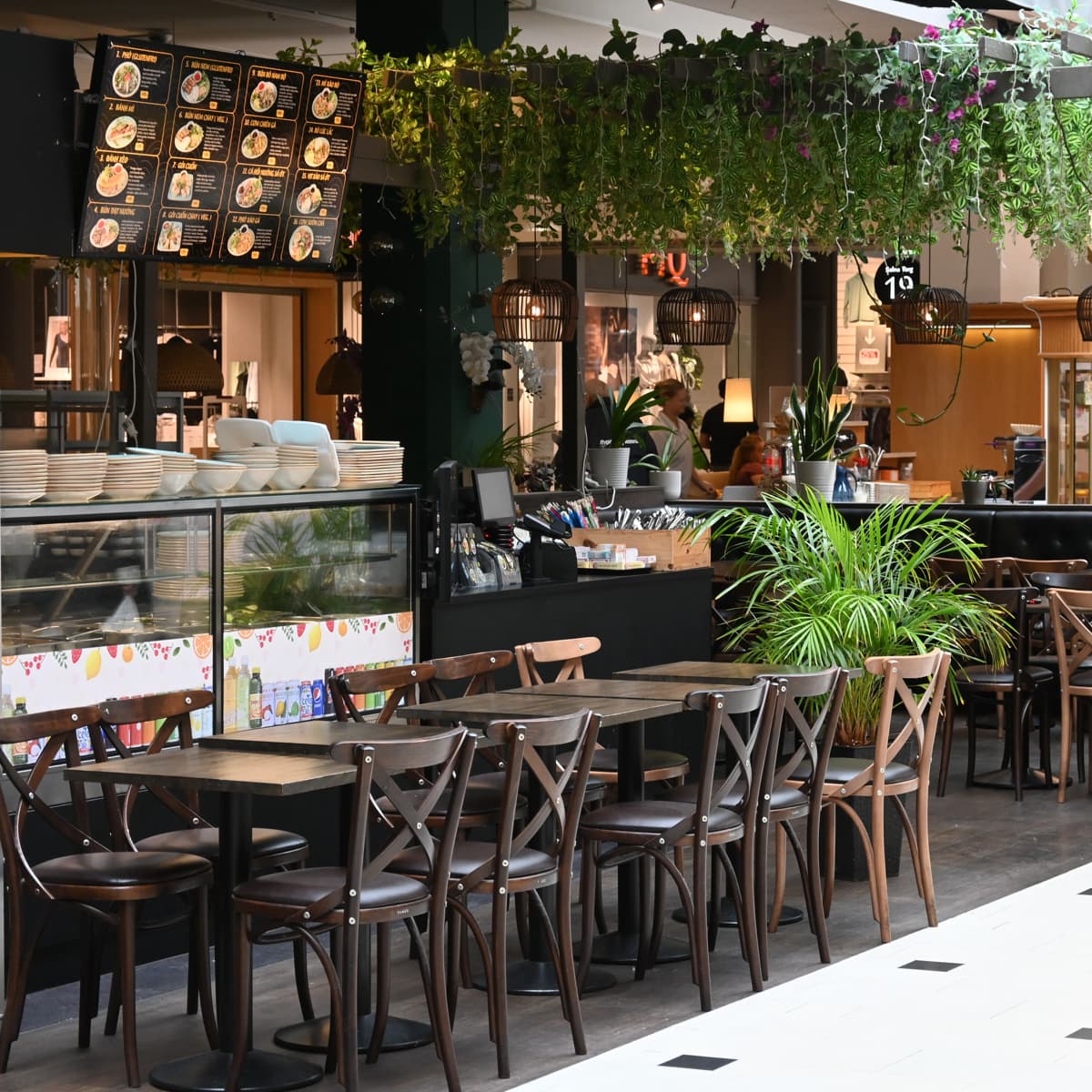 En restaurang med många bord och stolar utomhus.