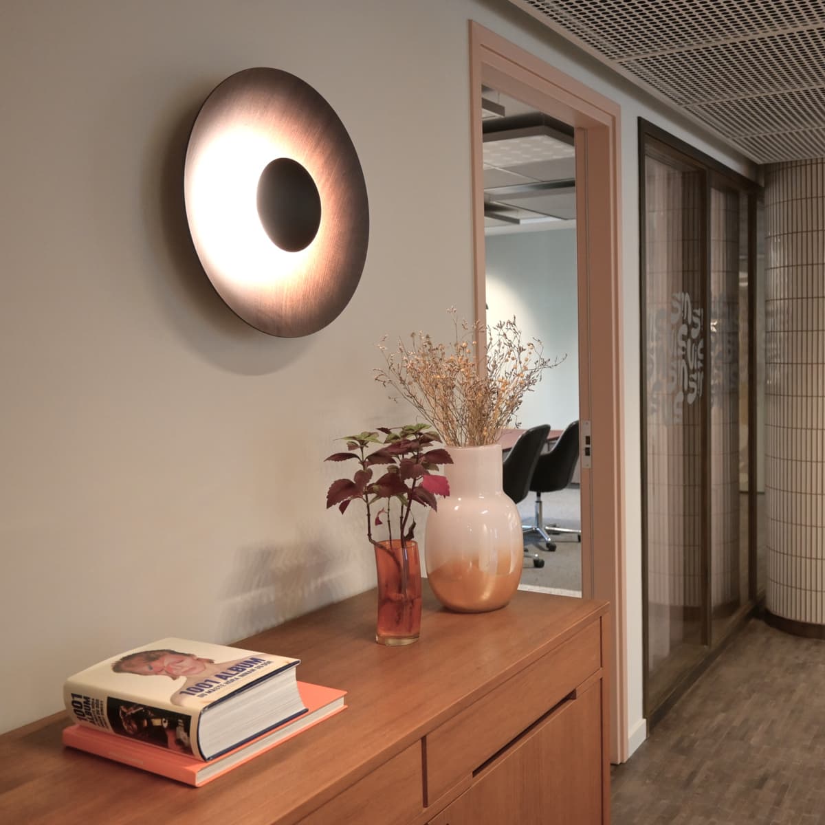 Ett rum med ett träbord och en spegel på väggen.