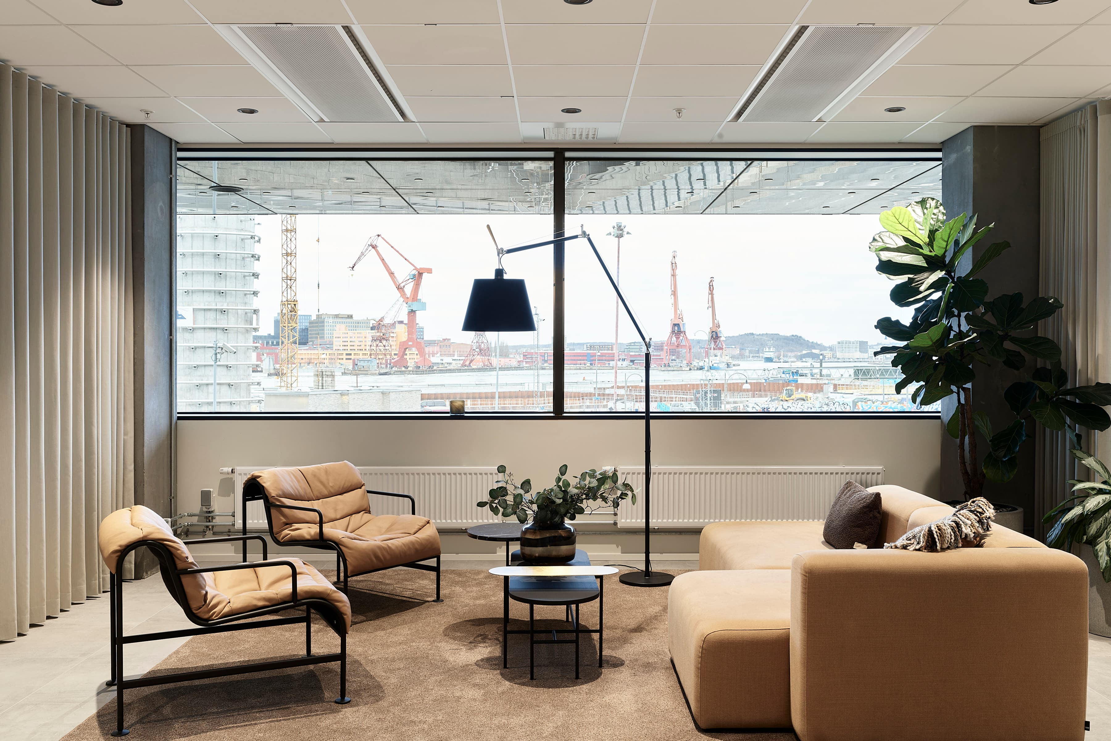 Ett vardagsrum fyllt med möbler och ett stort fönster.