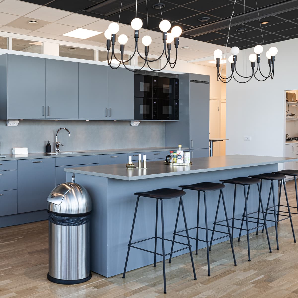 Ett kök med en mittö omgiven av stolar.