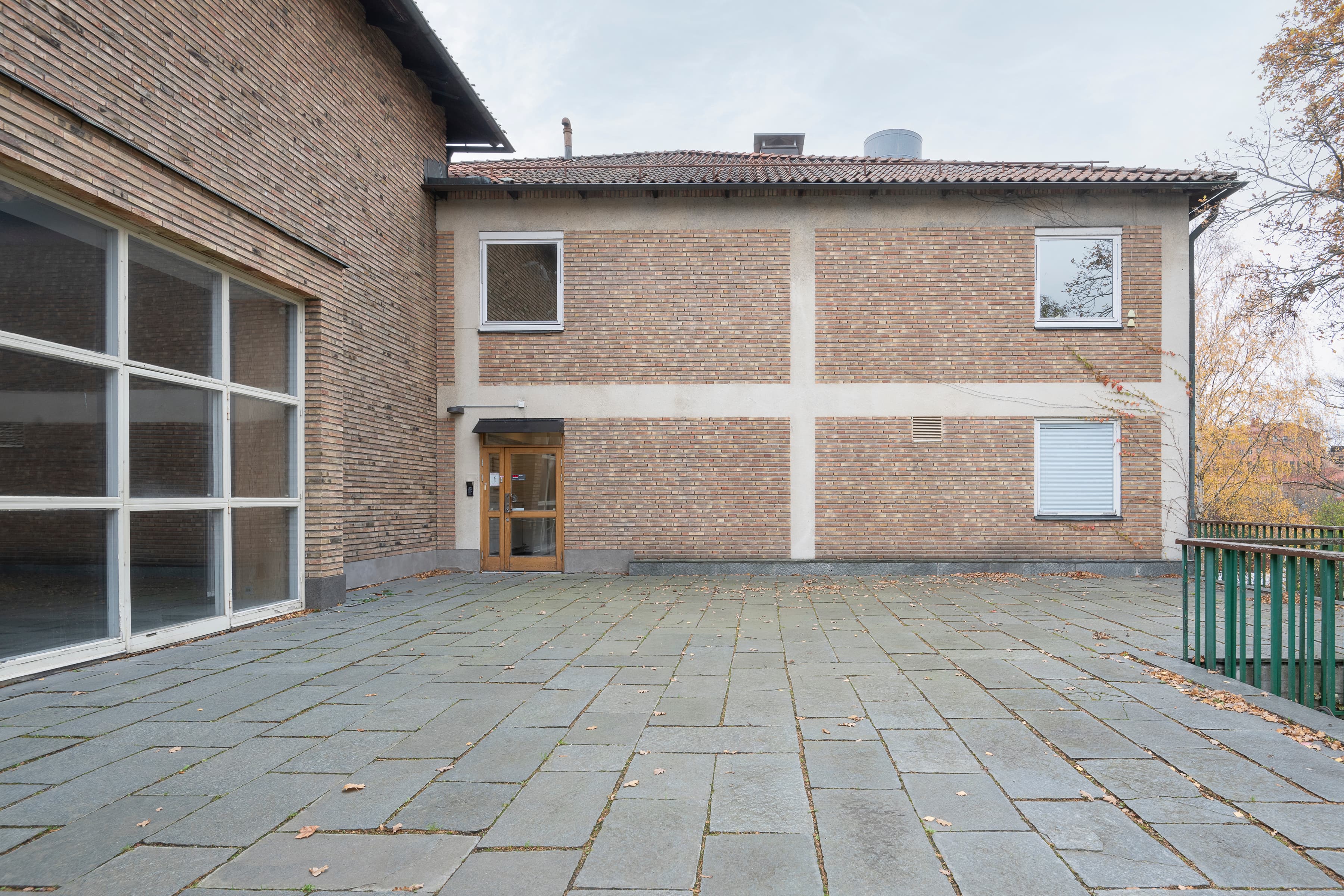 En stor tegelbyggnad med en grön port.