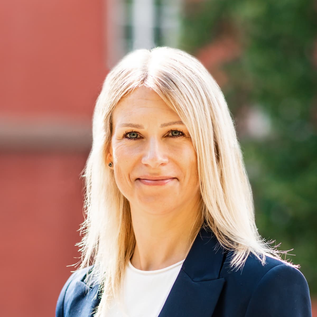 En kvinna som står framför en tegelvägg.