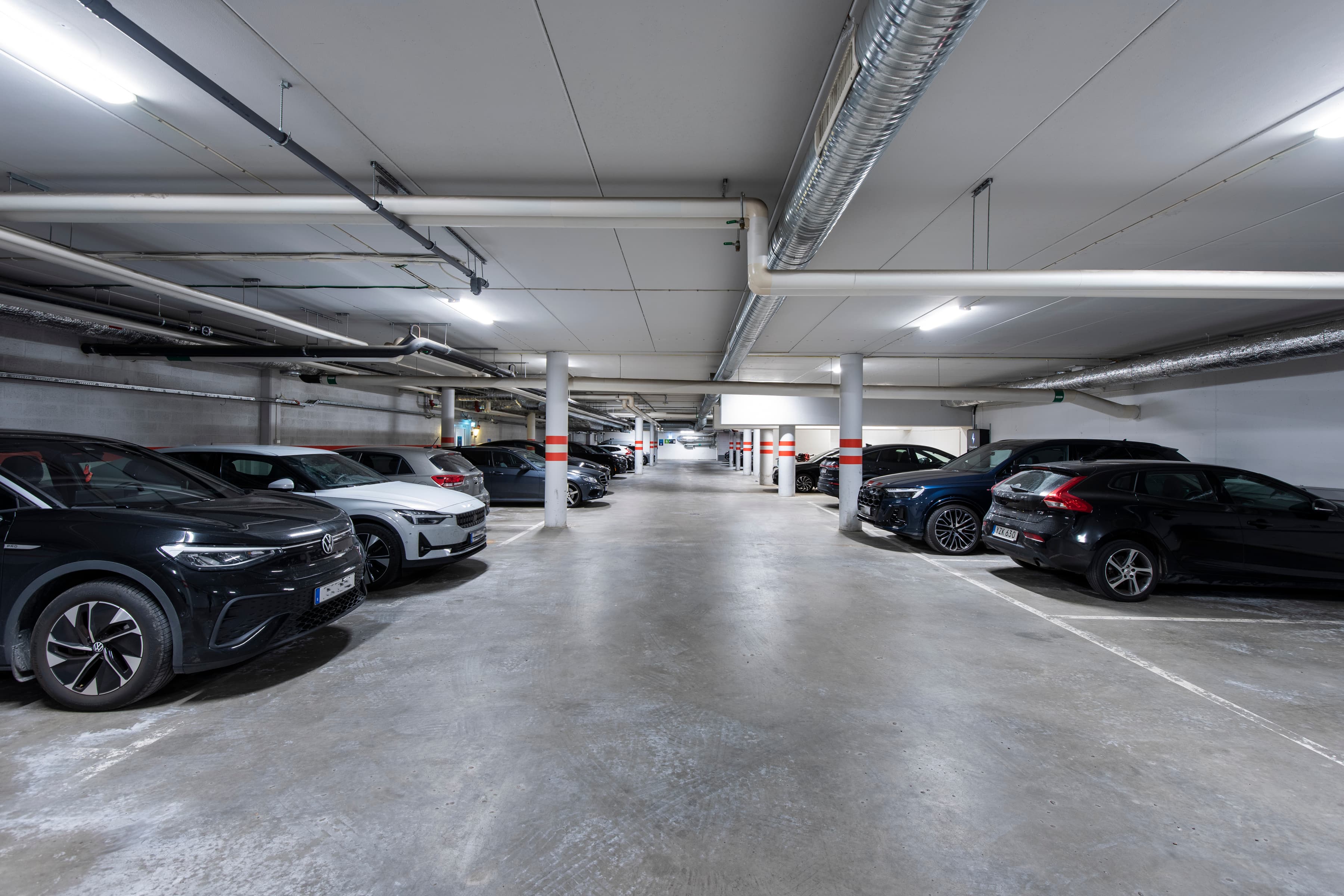 Ett parkeringsgarage med flera bilar parkerade i det.