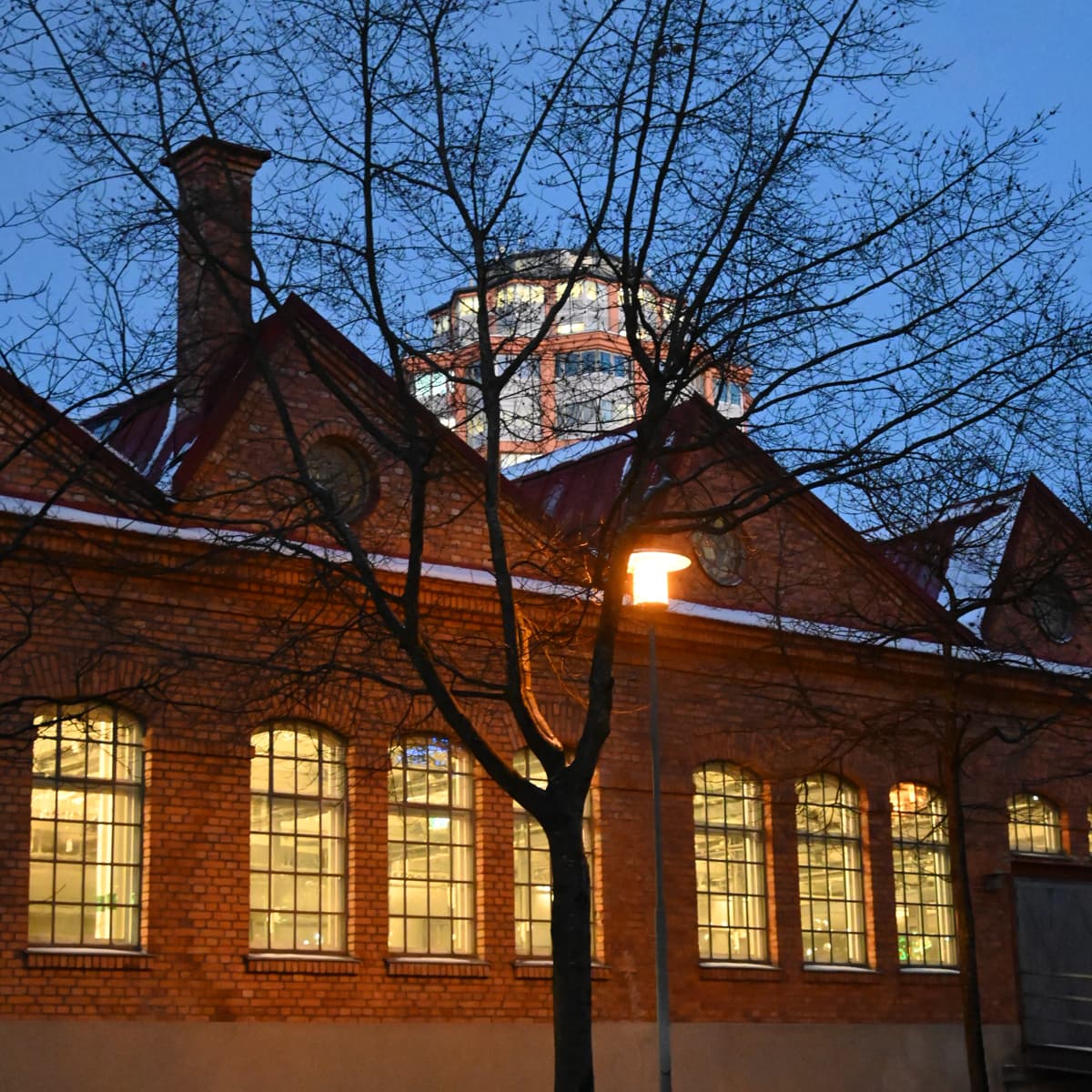 En byggnad med ett klocktorn som är upplyst på natten.