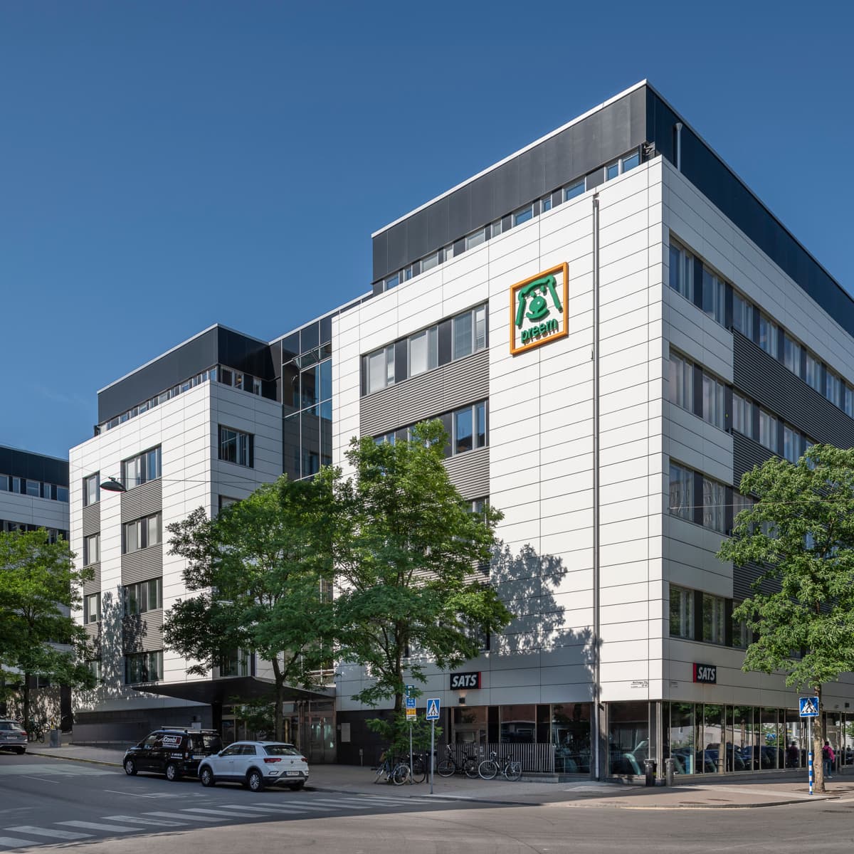 En stor vit byggnad som står vid sidan av en väg.