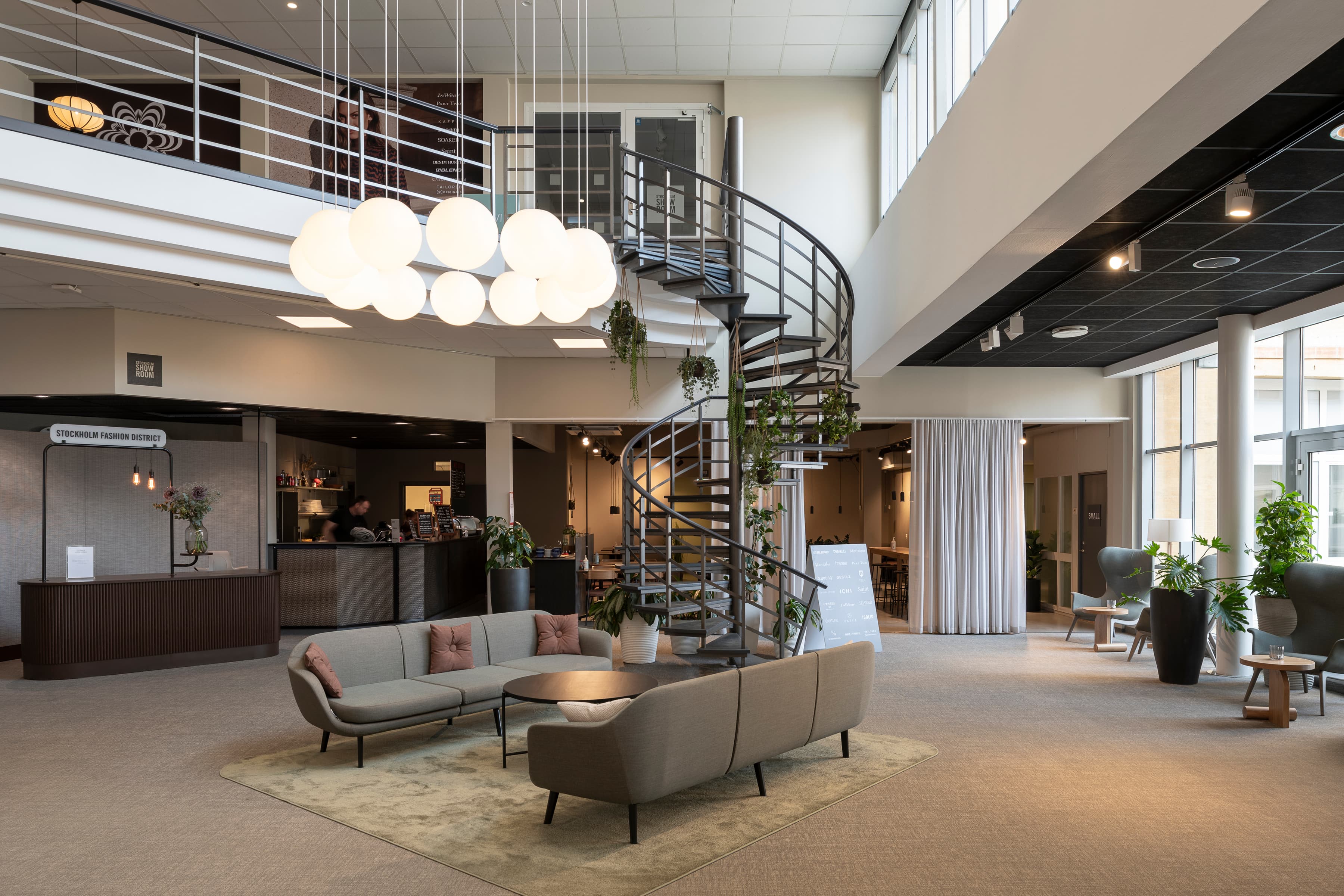 Ett vardagsrum fyllt med möbler och en spiraltrappa.