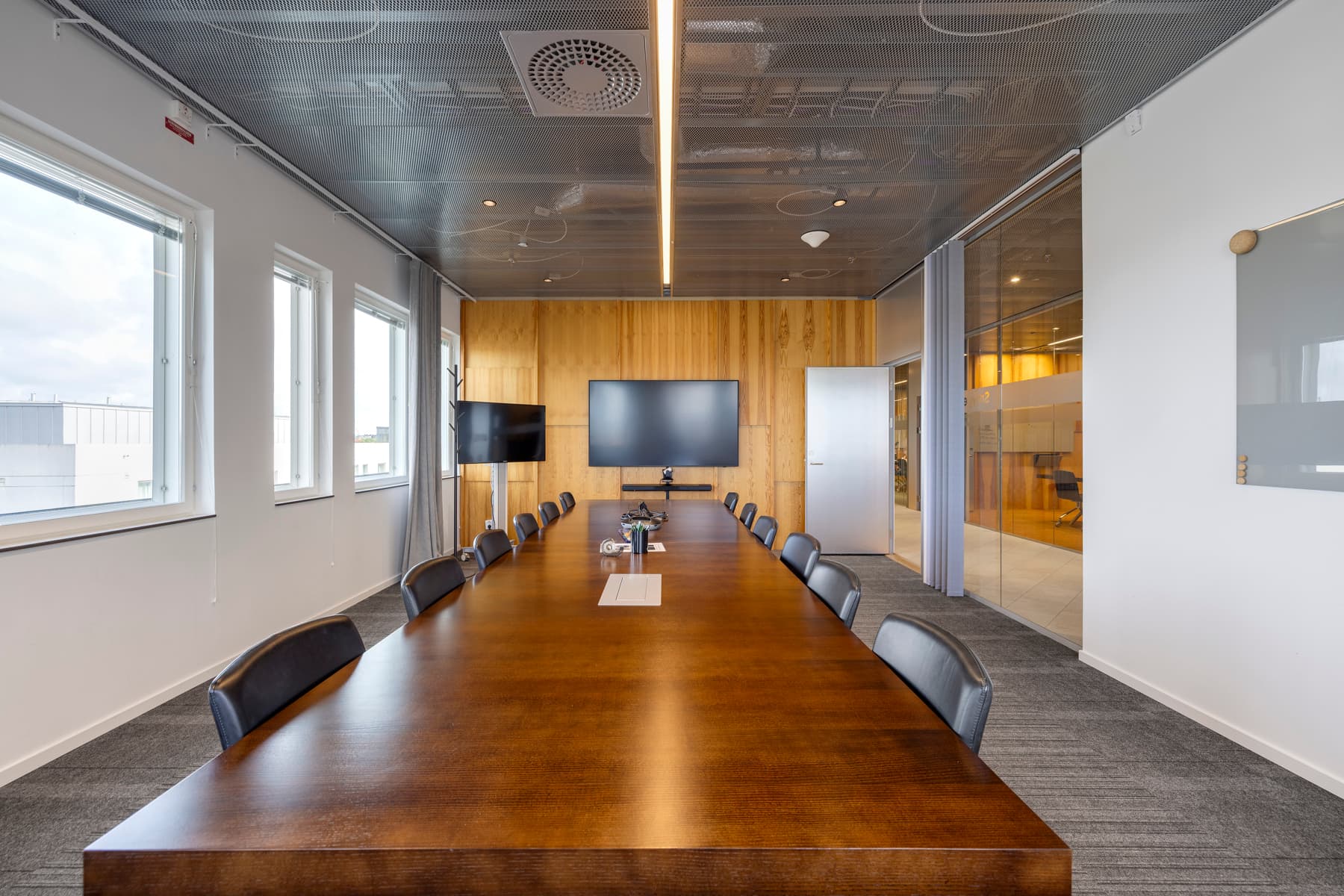 Ett konferensrum med ett stort träbord och stolar.