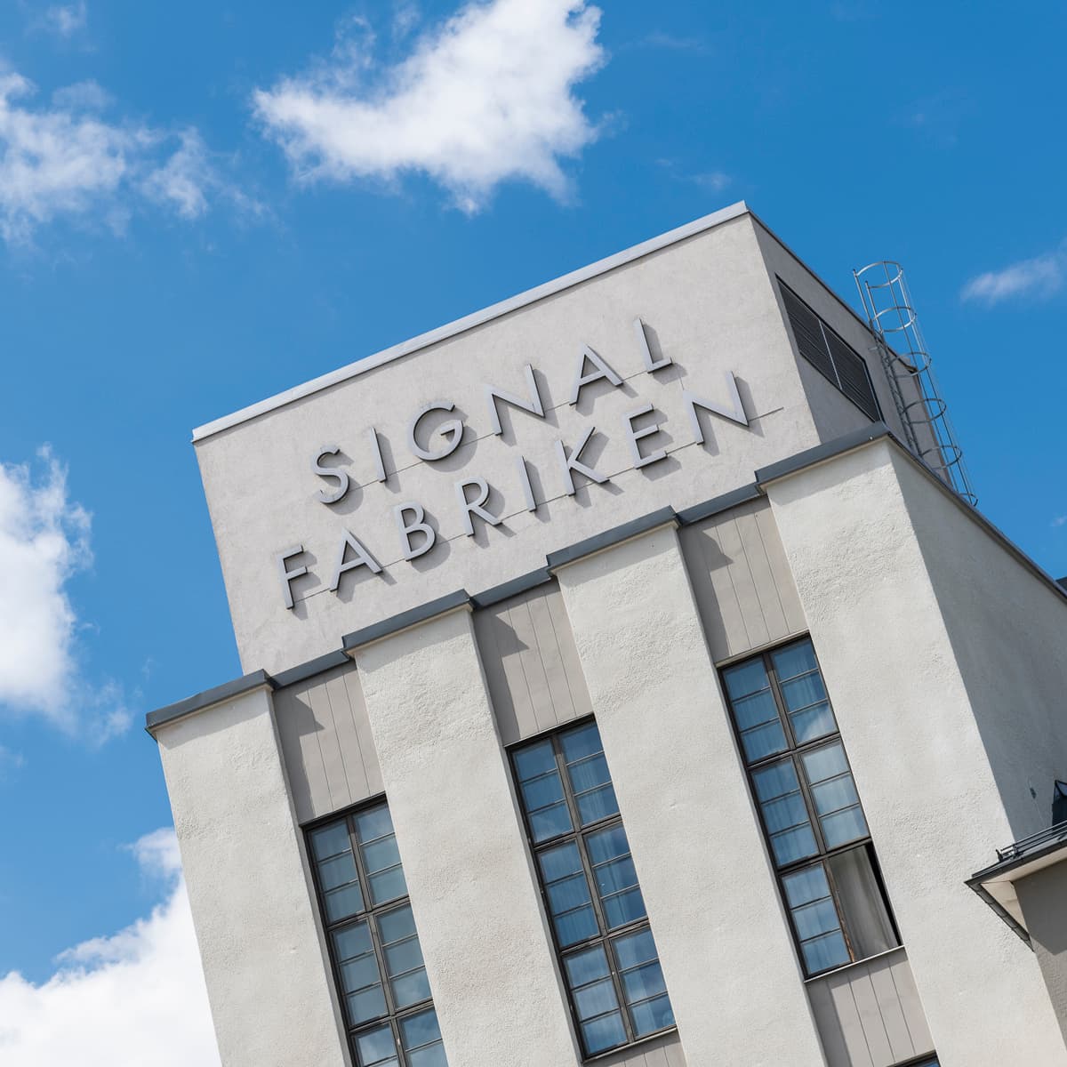 En hög byggnad med en skylt på toppen av den.