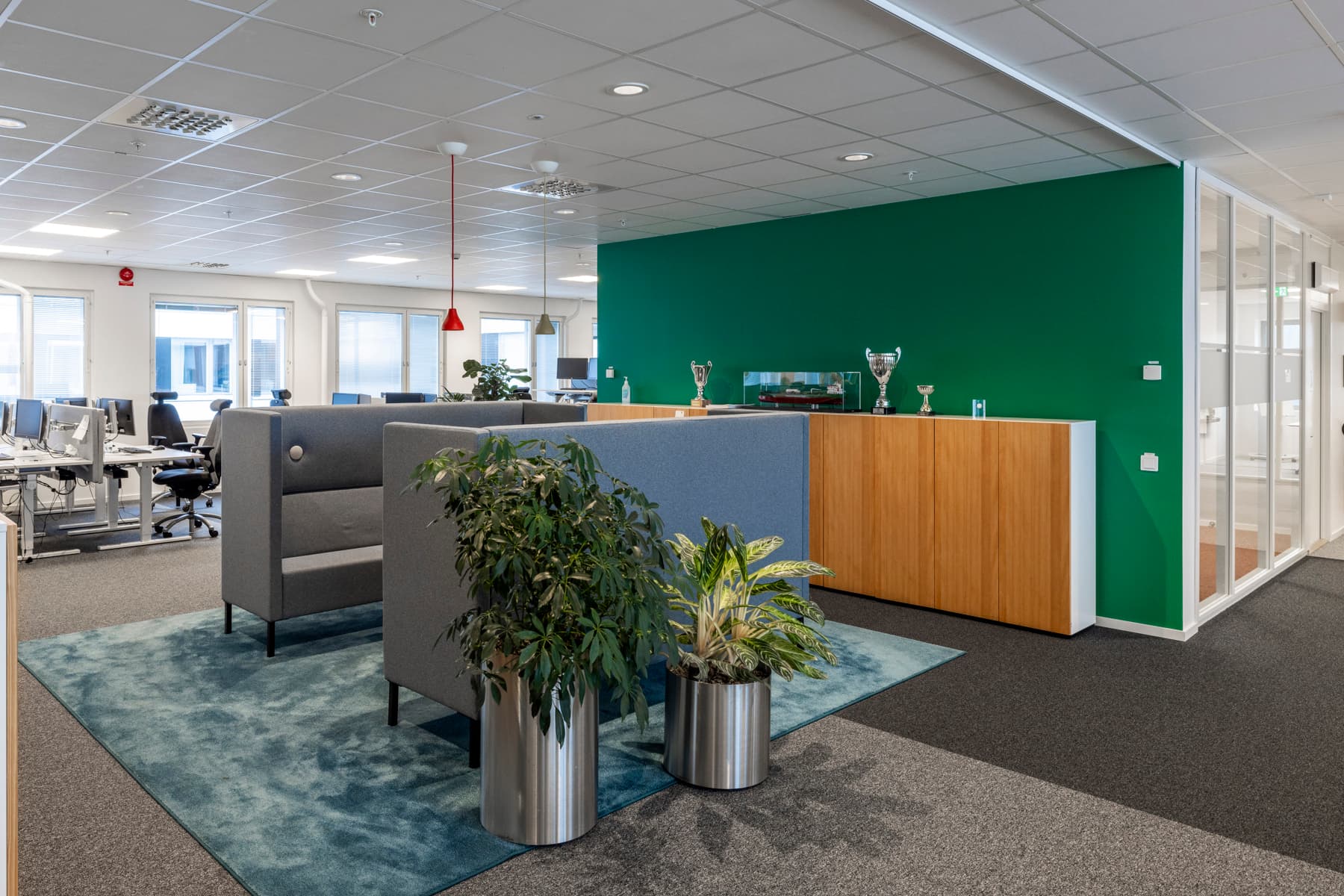 Ett kontor med en grön vägg och två planteringskärl.