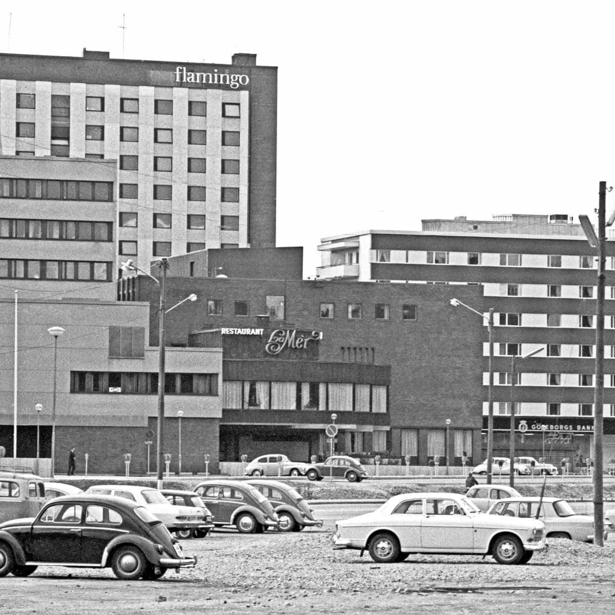 Ett svartvitt foto av bilar som står parkerade på en parkeringsplats.