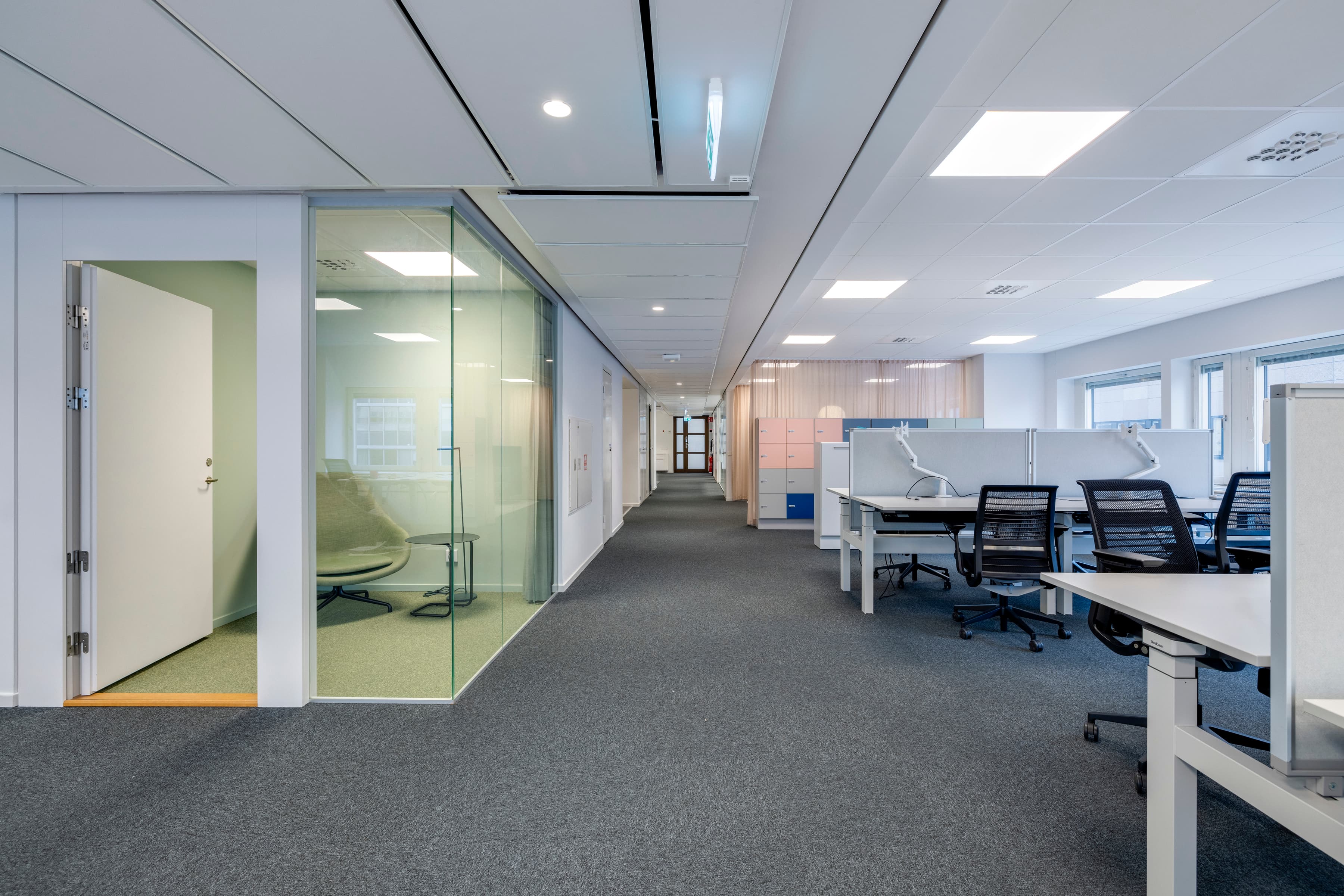 Ett tomt kontor med glasväggar och stolar.