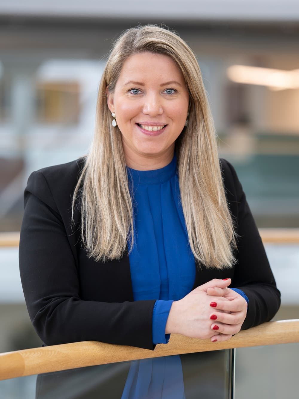 En kvinna står på en balkong med armarna i kors.