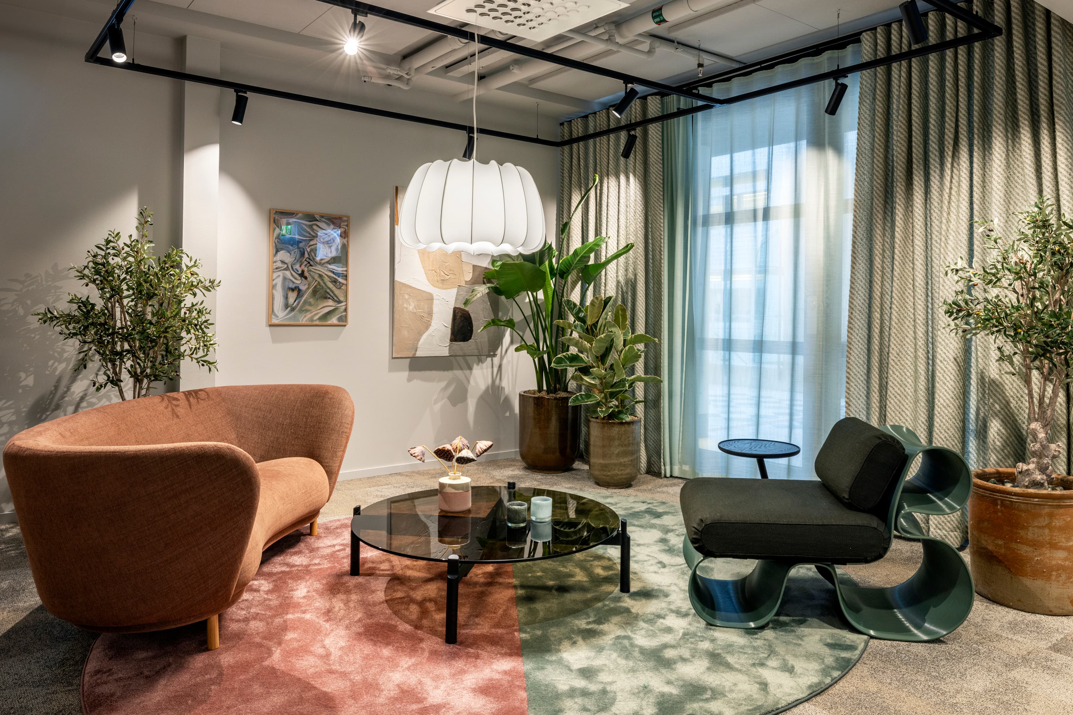 Ett vardagsrum fyllt med möbler och växter.