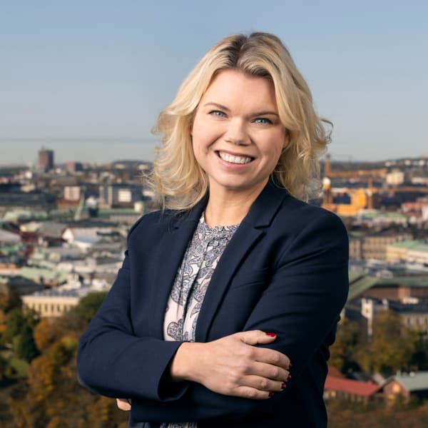 En kvinna står framför en stadssiluett.