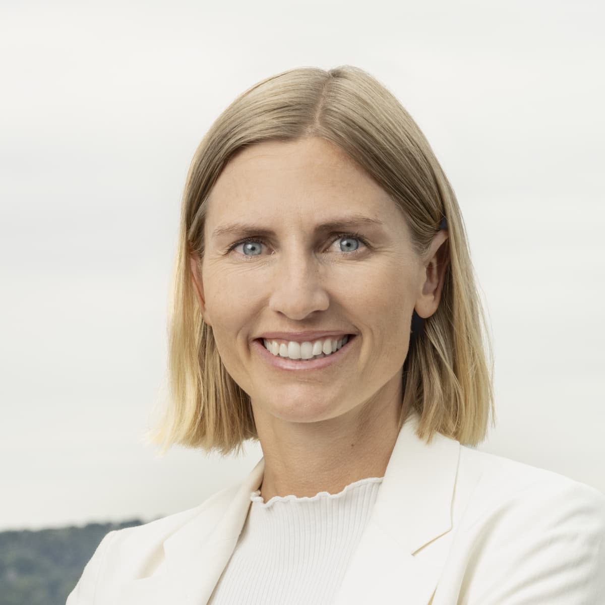 En kvinna står framför en stadsbild.