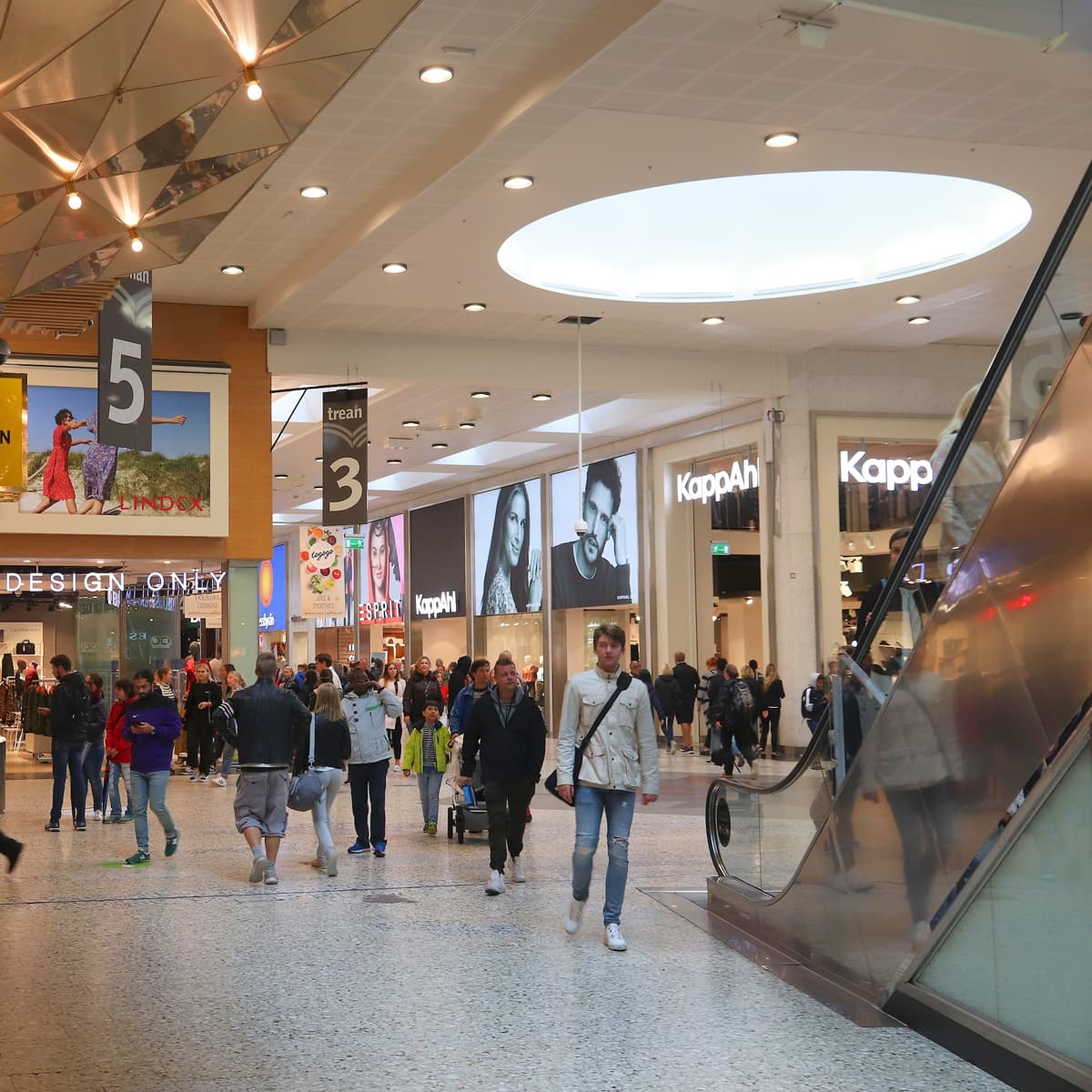 En grupp människor som går genom ett köpcentrum.