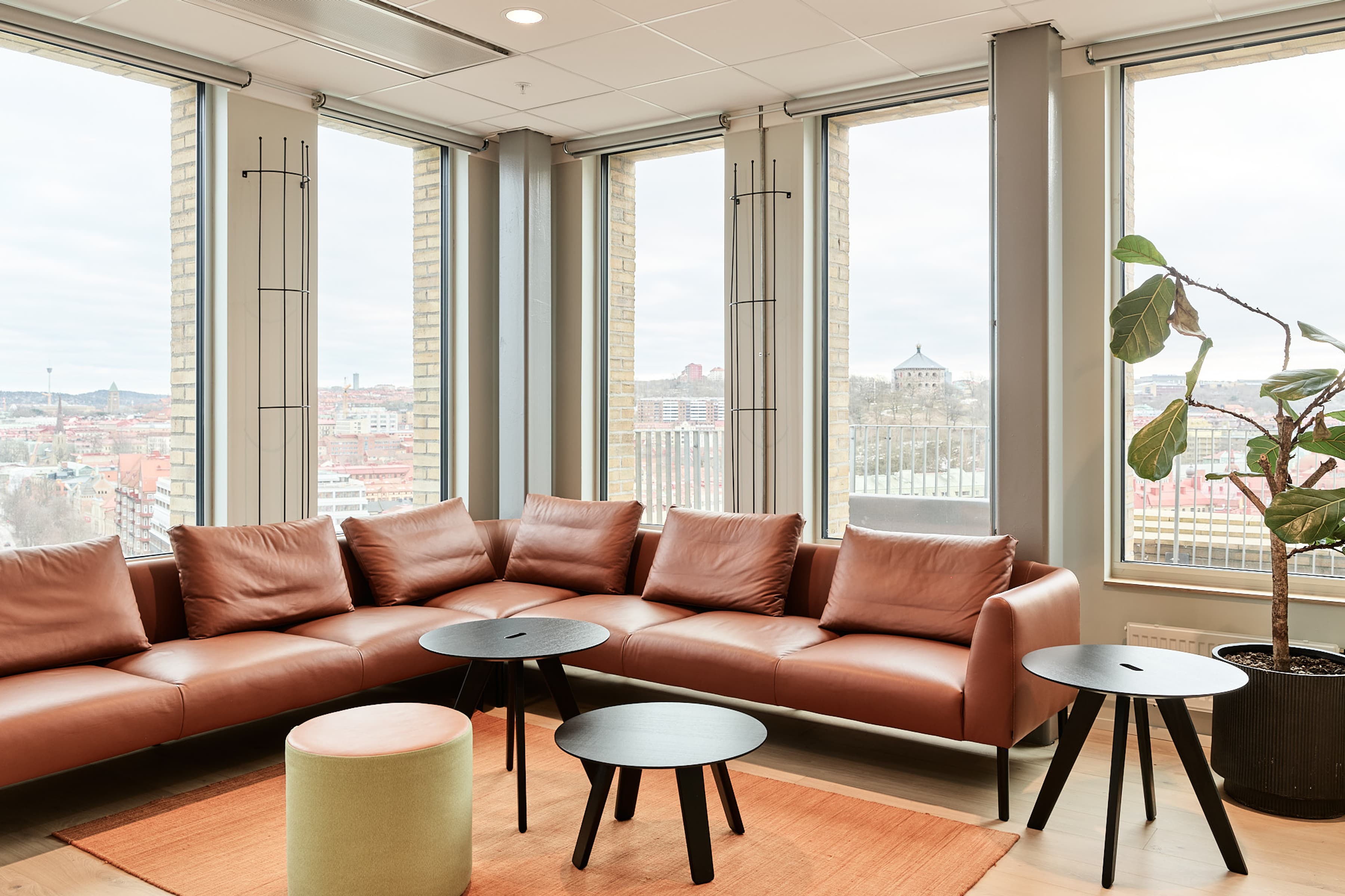 Ett vardagsrum fyllt med möbler och stora fönster.