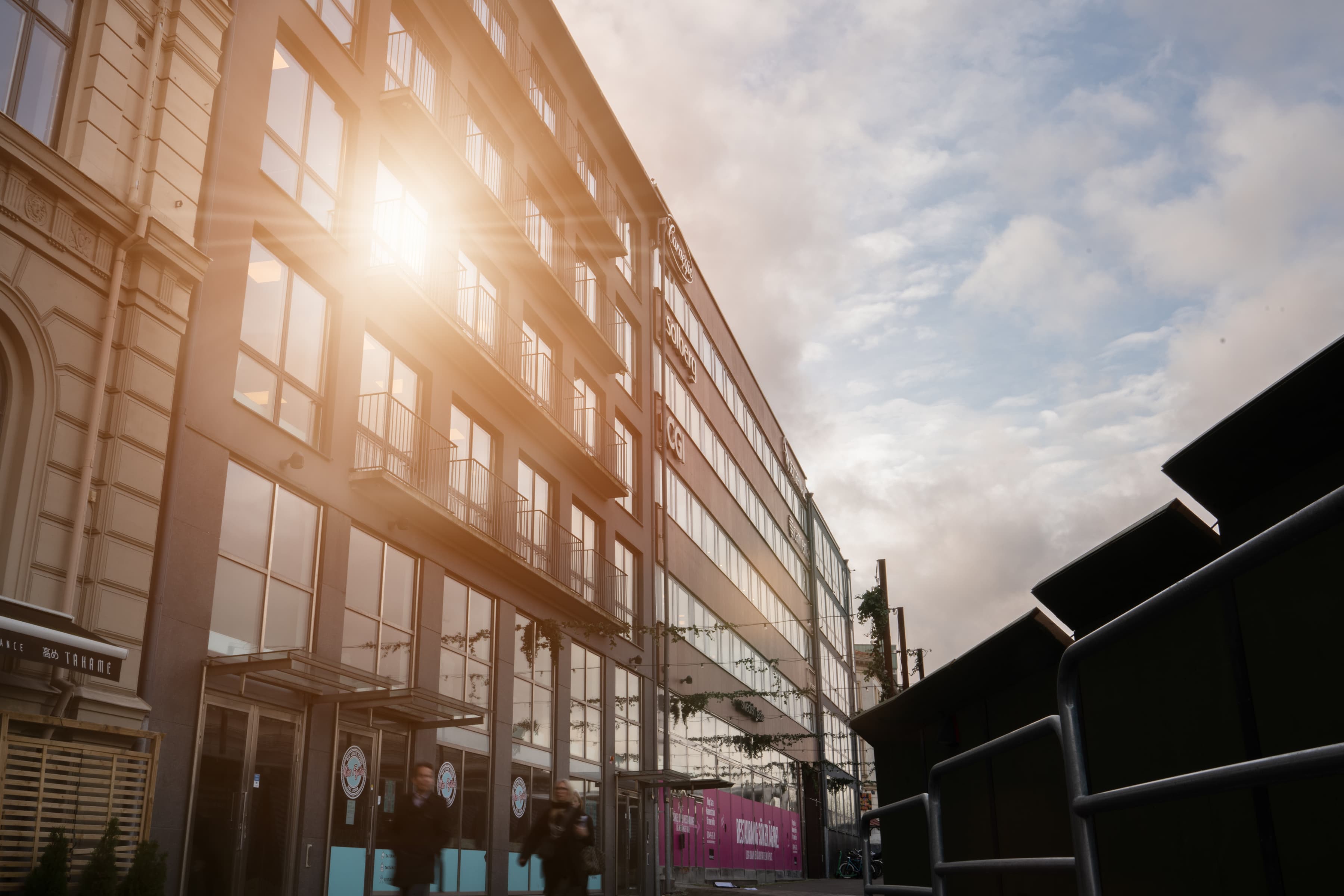 En man som går längs en gata bredvid en hög byggnad.