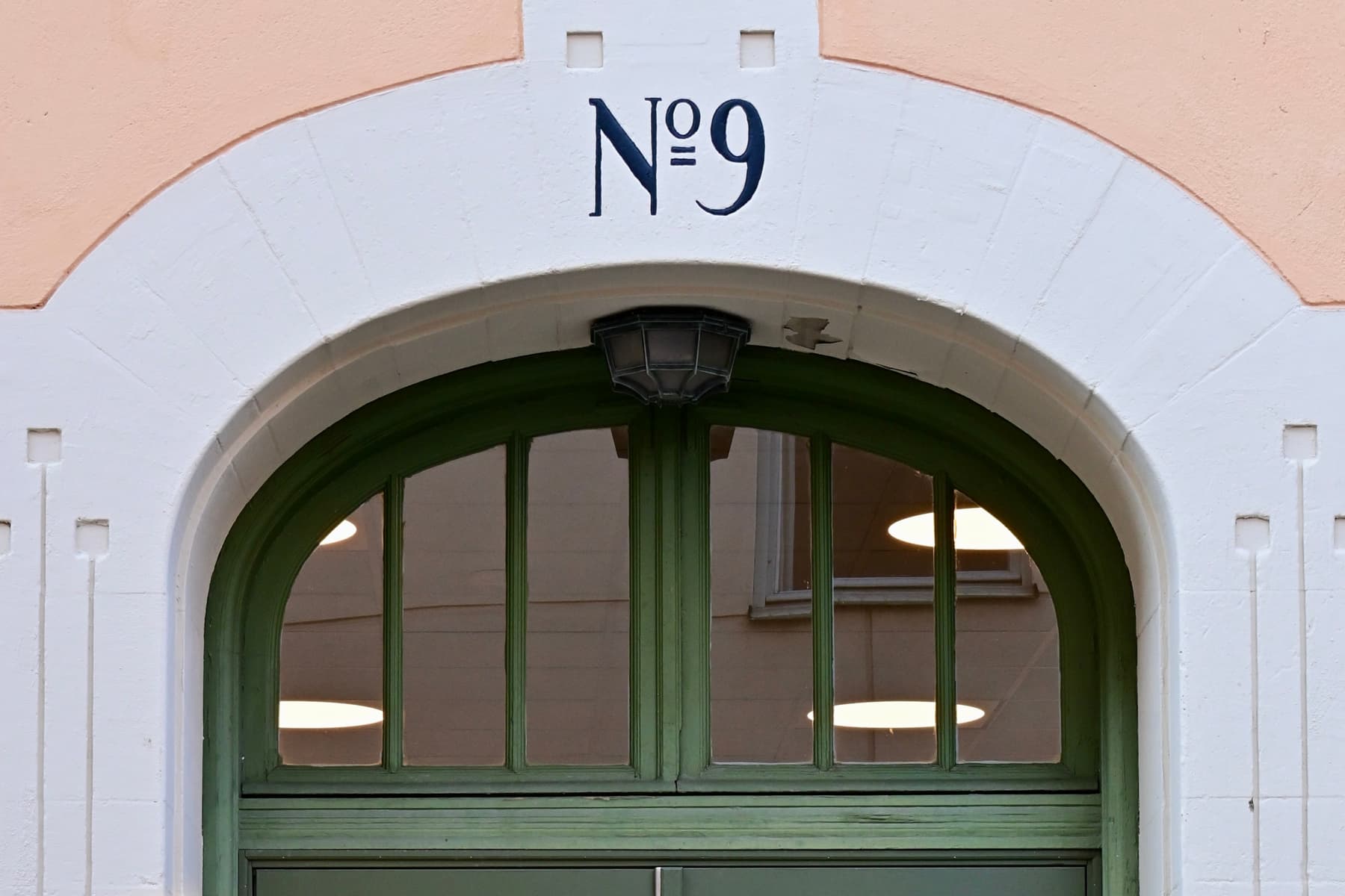 En grön dörr med en skylt på sidan av den.