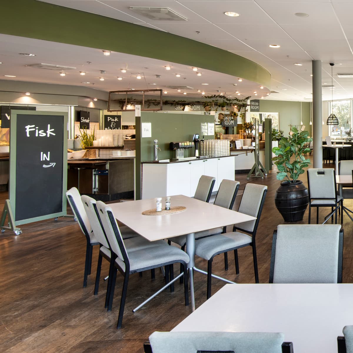 En restaurang fylld med många bord och stolar.