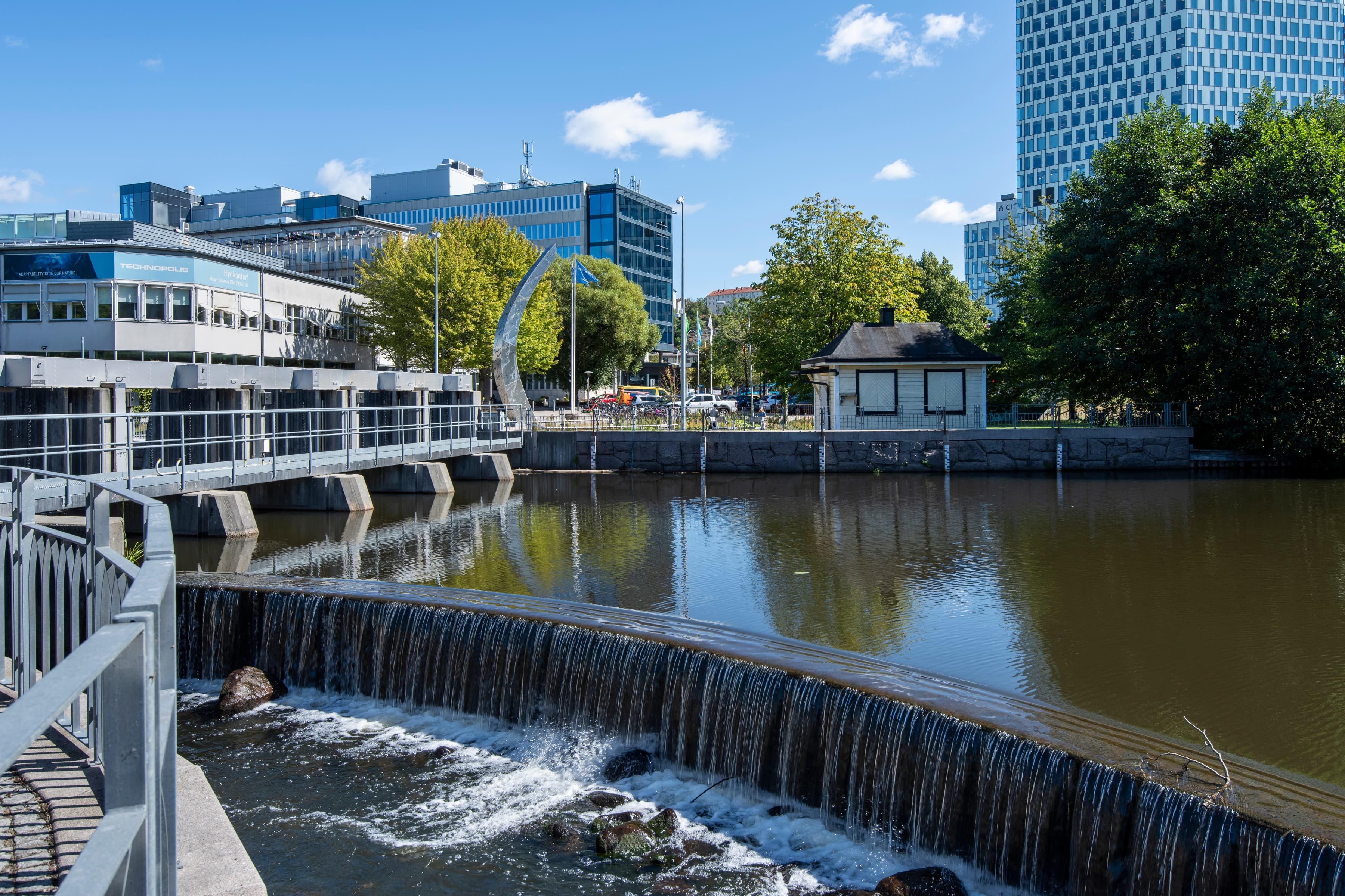 En flod som rinner genom en stad bredvid höga byggnader.