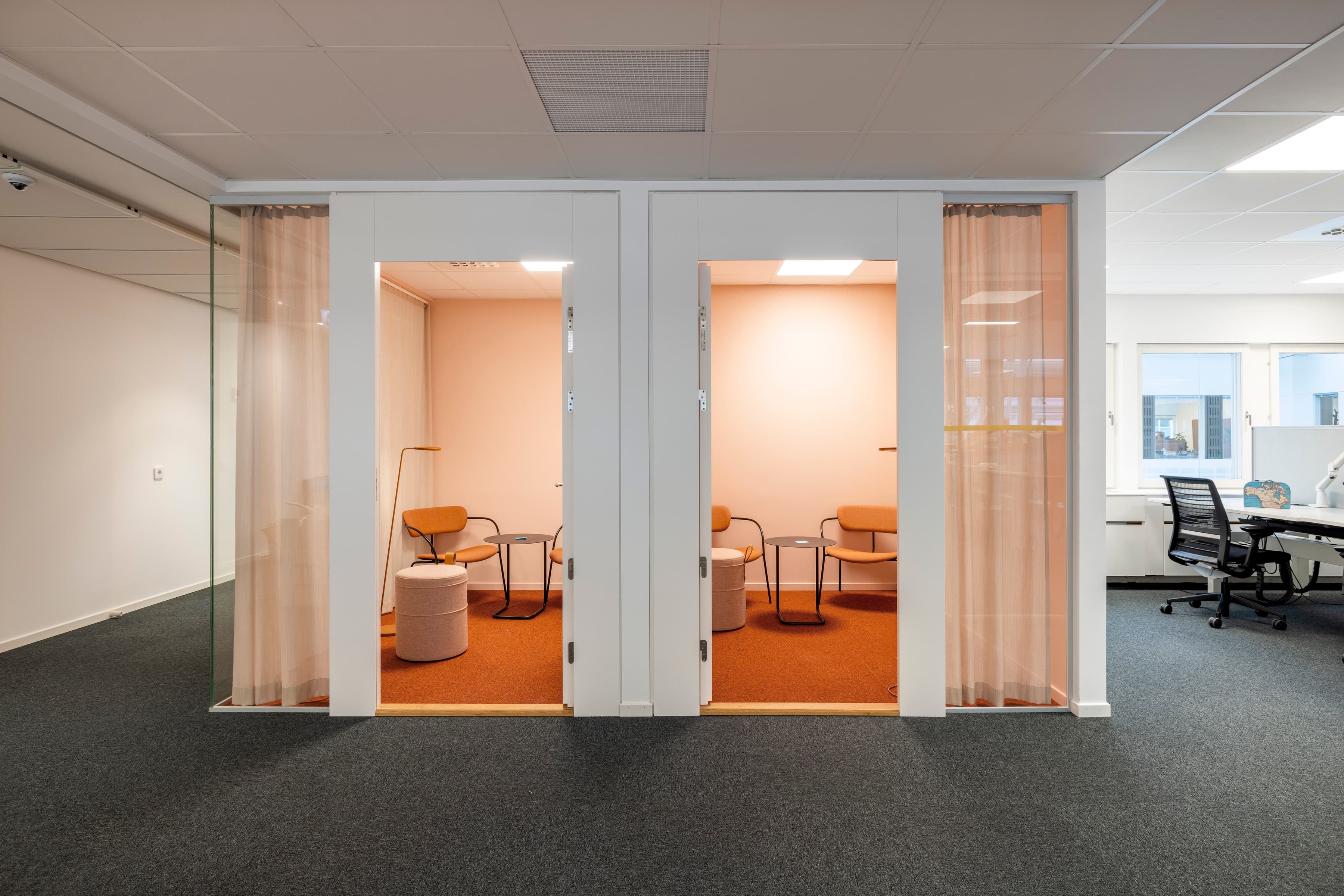 Ett kontor med två dörrar öppna till ett mötesrum.