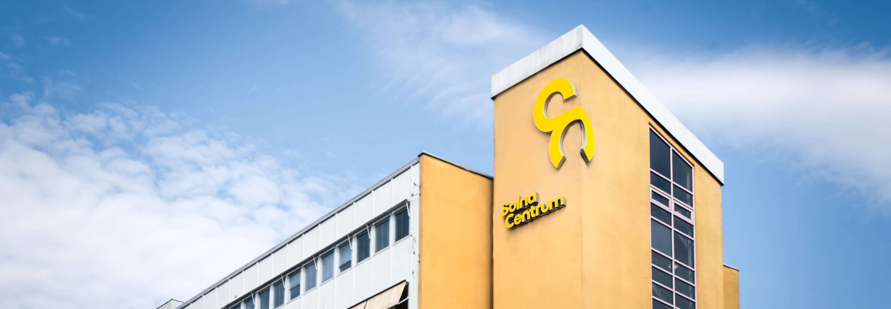 En stor byggnad med en gul och svart logotyp på.