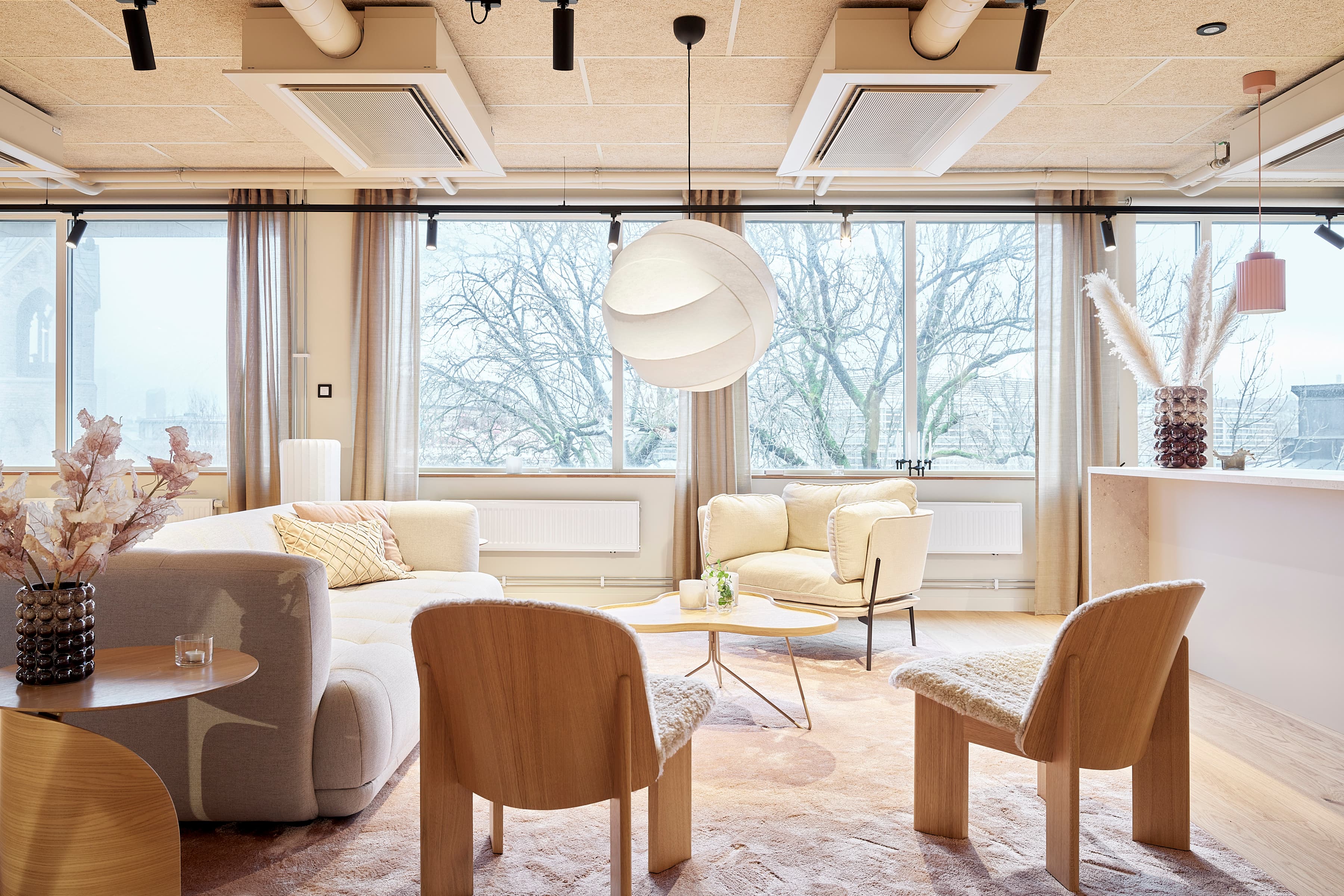 Ett vardagsrum fyllt med möbler och ett stort fönster.