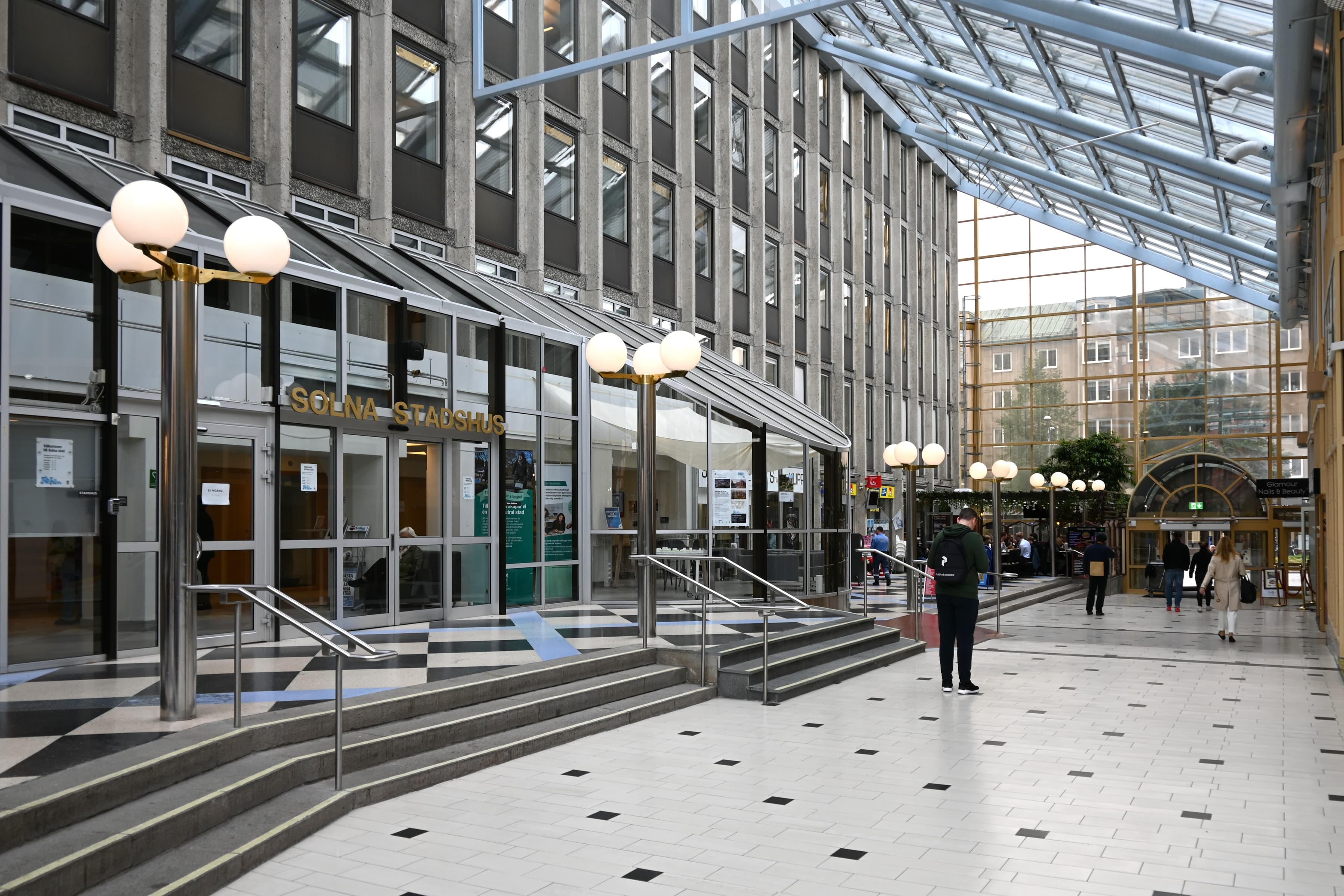 En grupp människor som går längs en korridor i en byggnad.