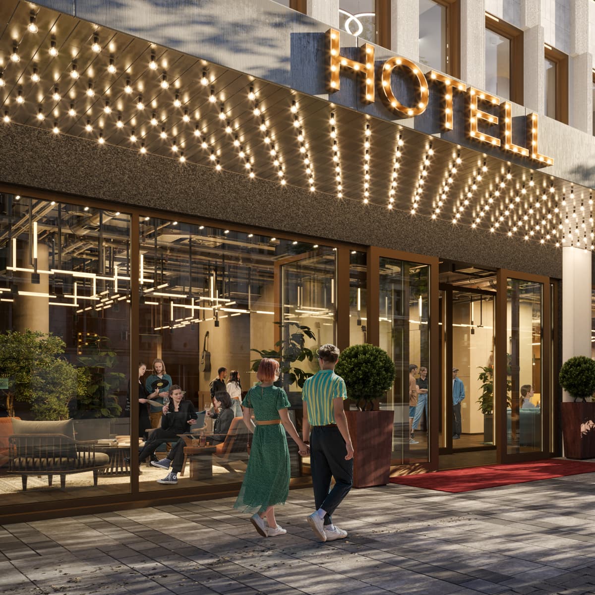 En grupp människor som går längs en gata bredvid en hög byggnad.