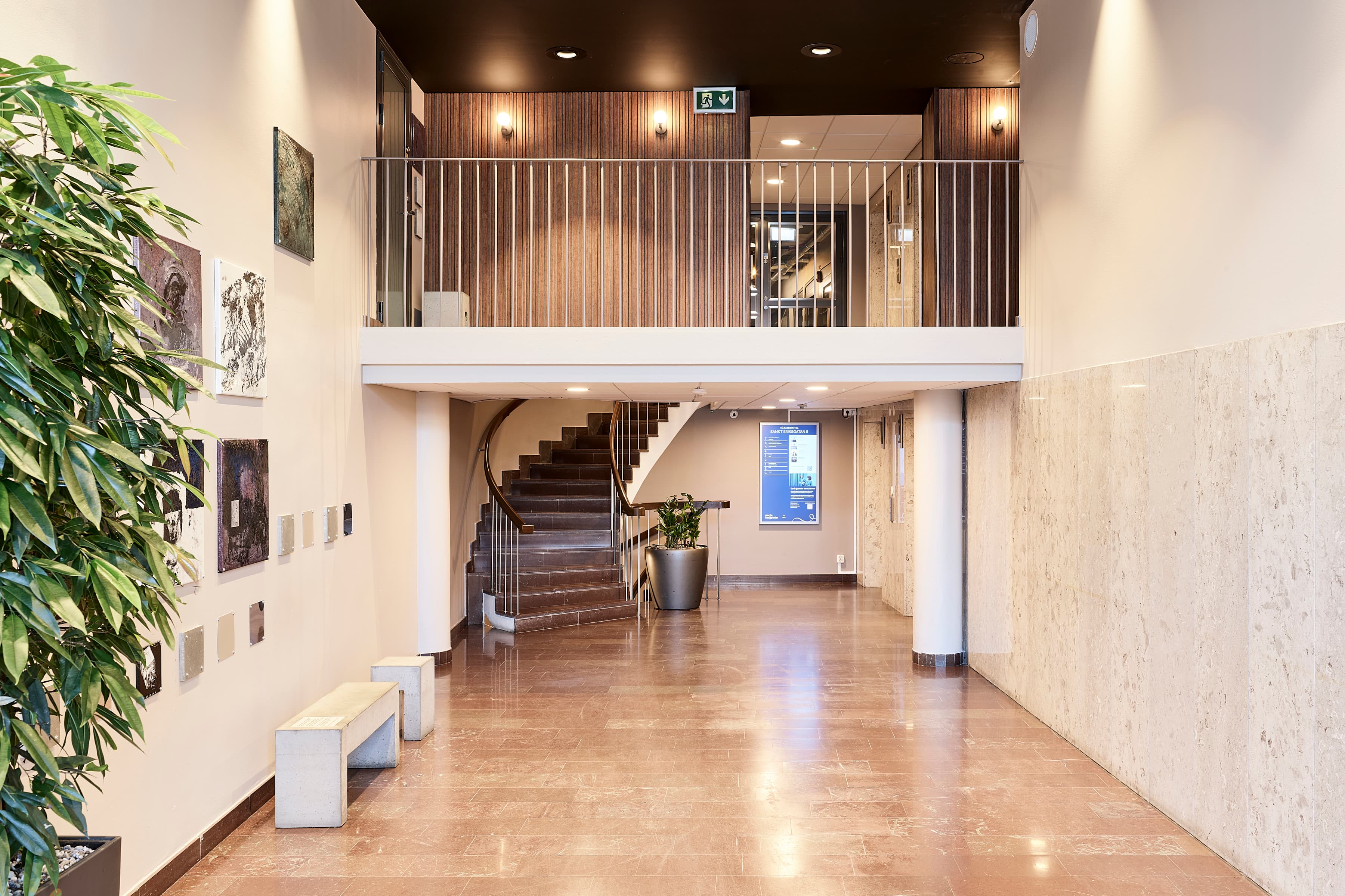 Ett stort rum med en trappa och en krukväxt.