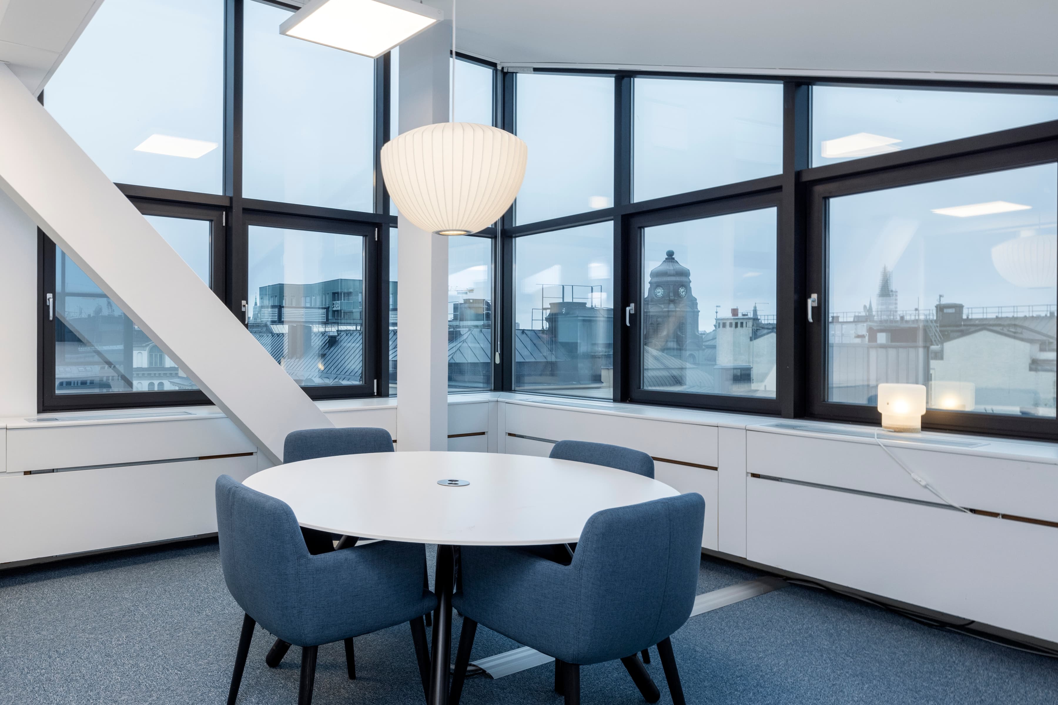 Ett bord och stolar i ett rum med stora fönster.