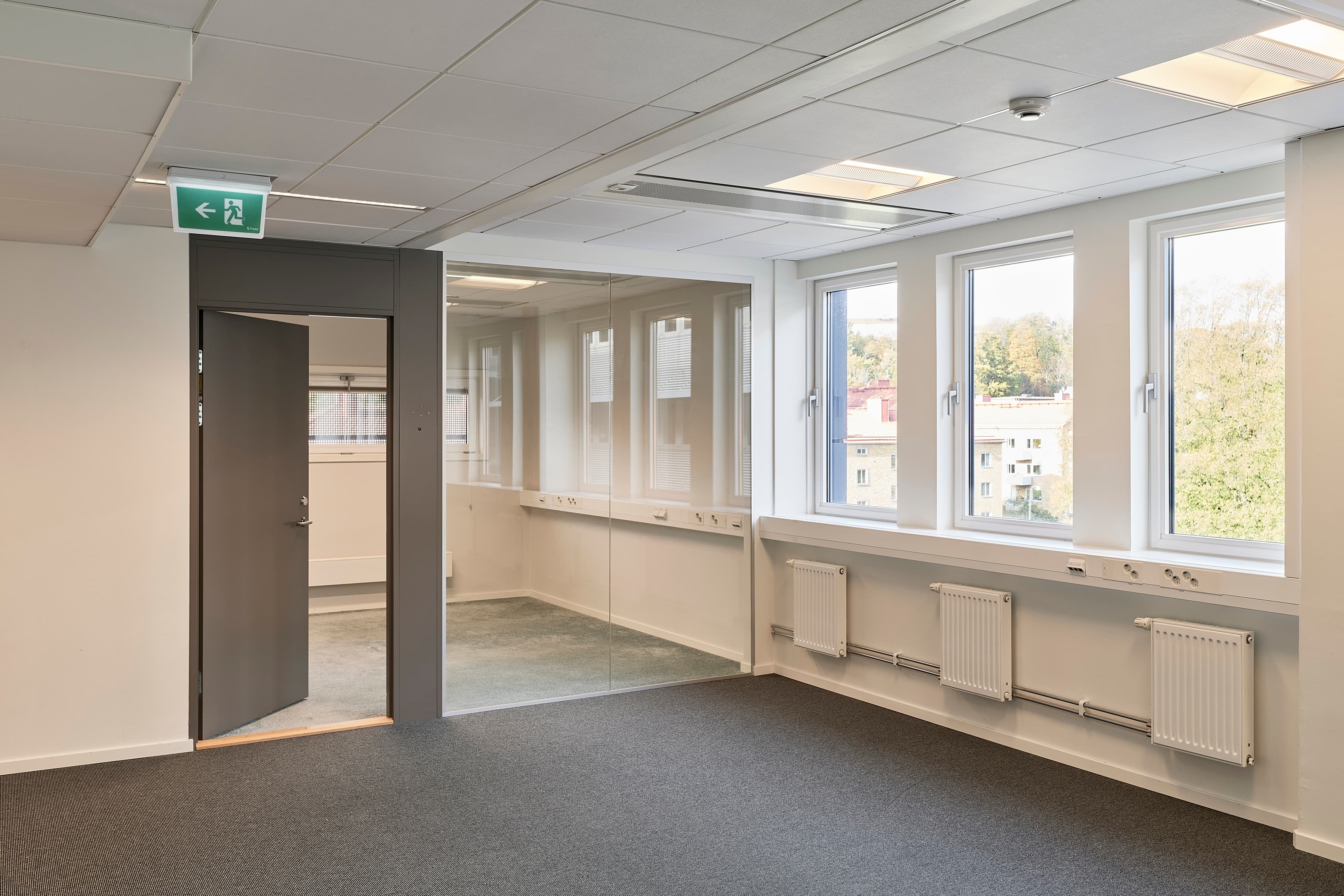 Ett tomt rum med en dörr och fönster.