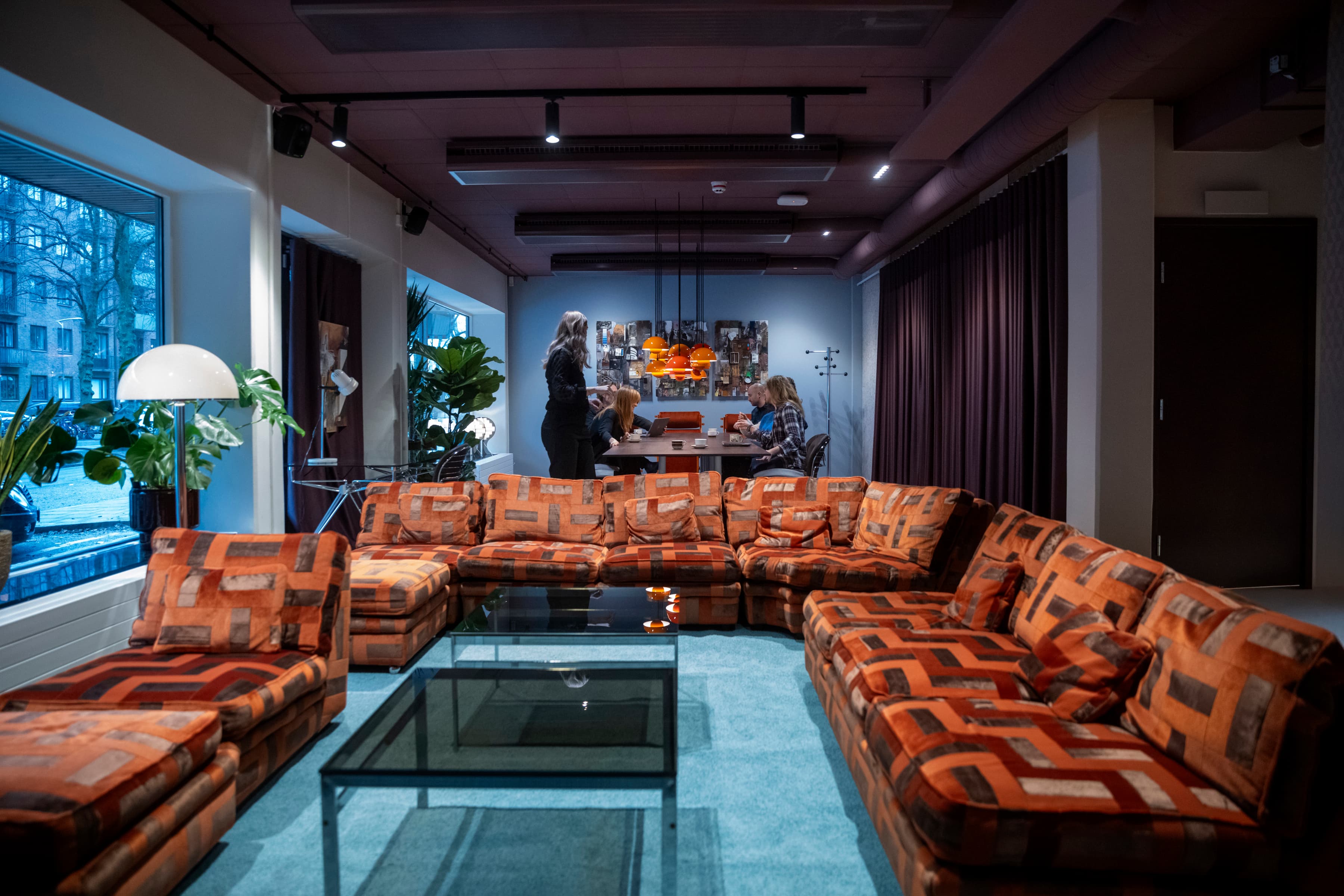 En coworking fyllt med möbler och ett stort fönster.