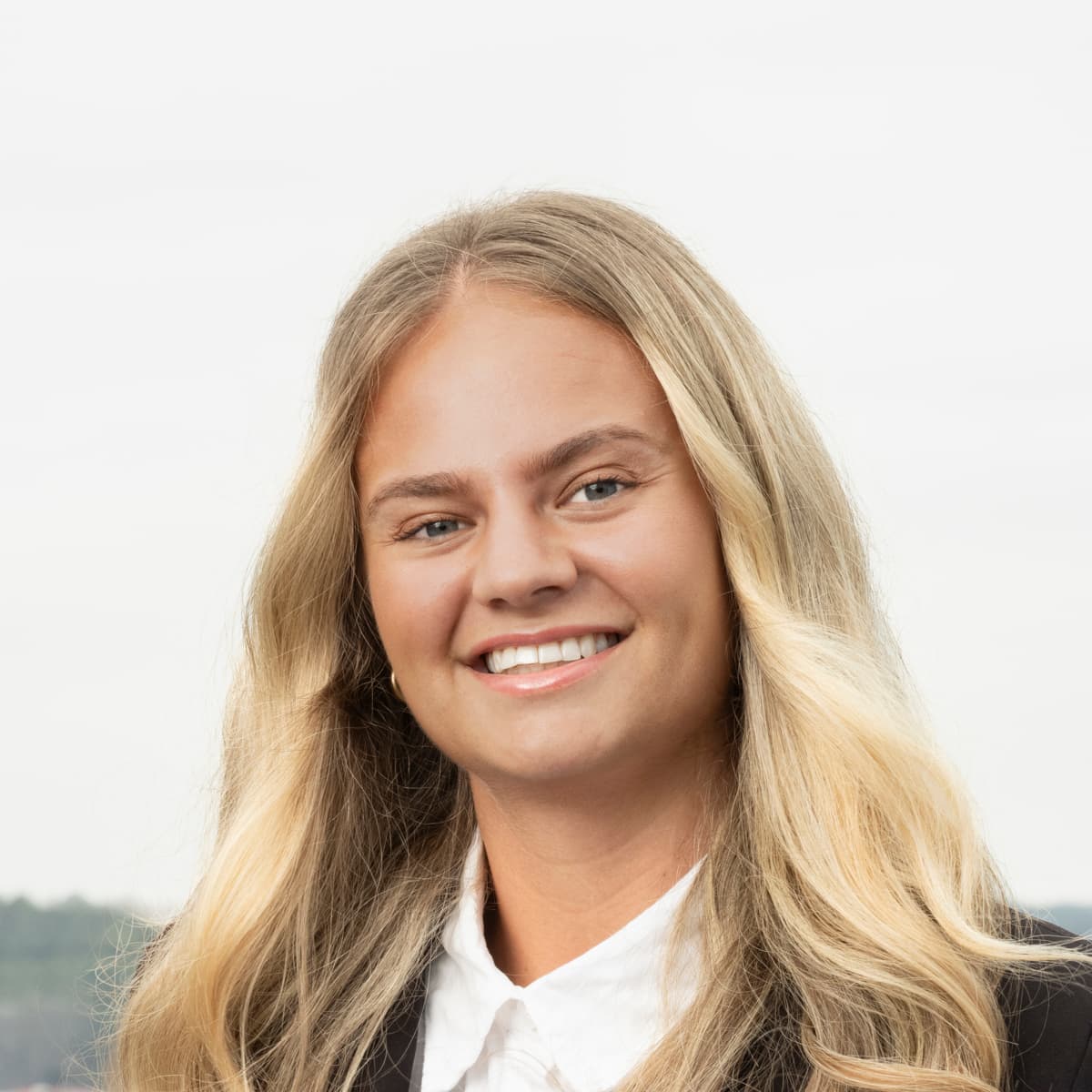 En kvinna står framför en stadsbild.