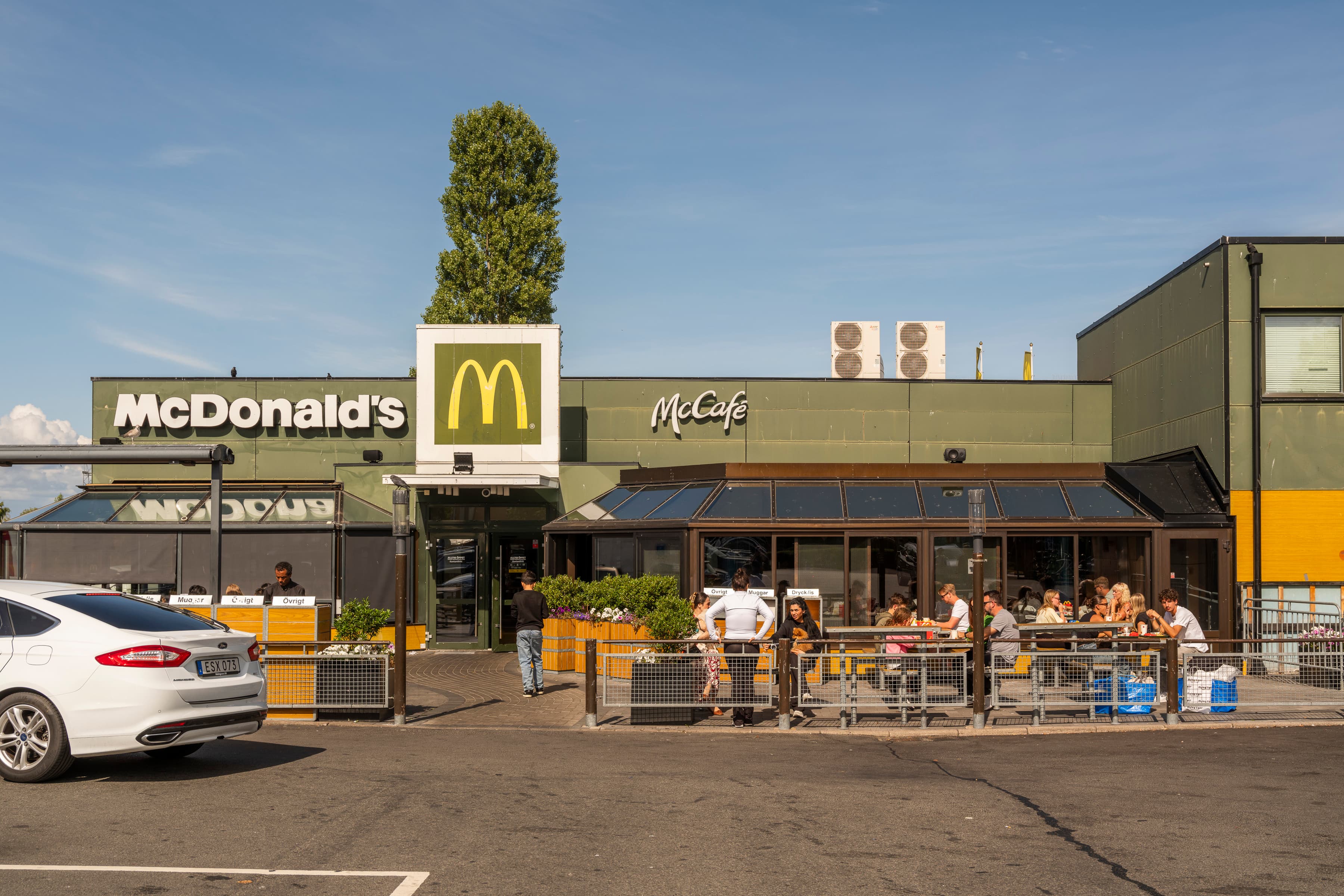 En McDonald’s-restaurang med en bil parkerad framför.