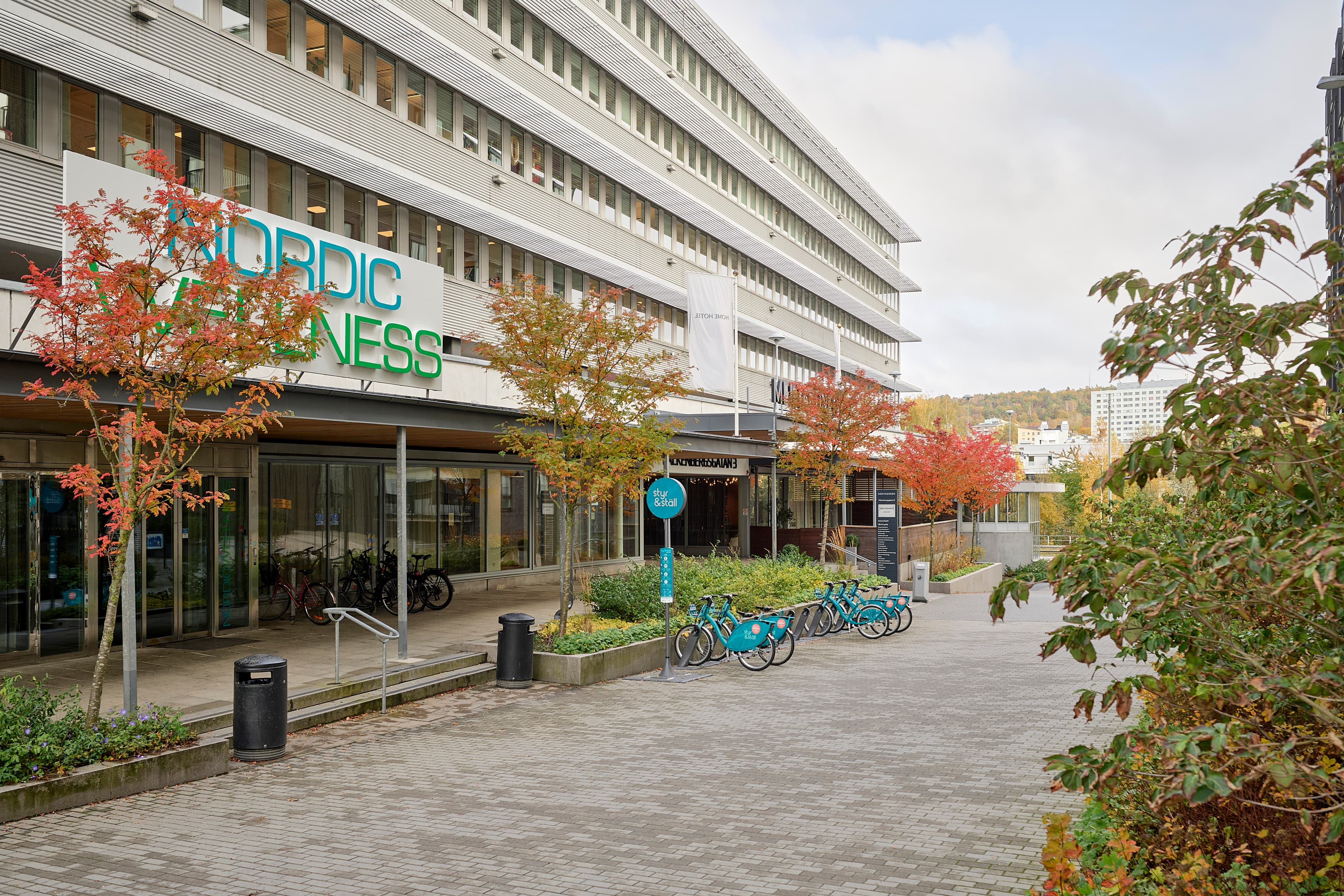 En rad cyklar parkerade framför en byggnad.