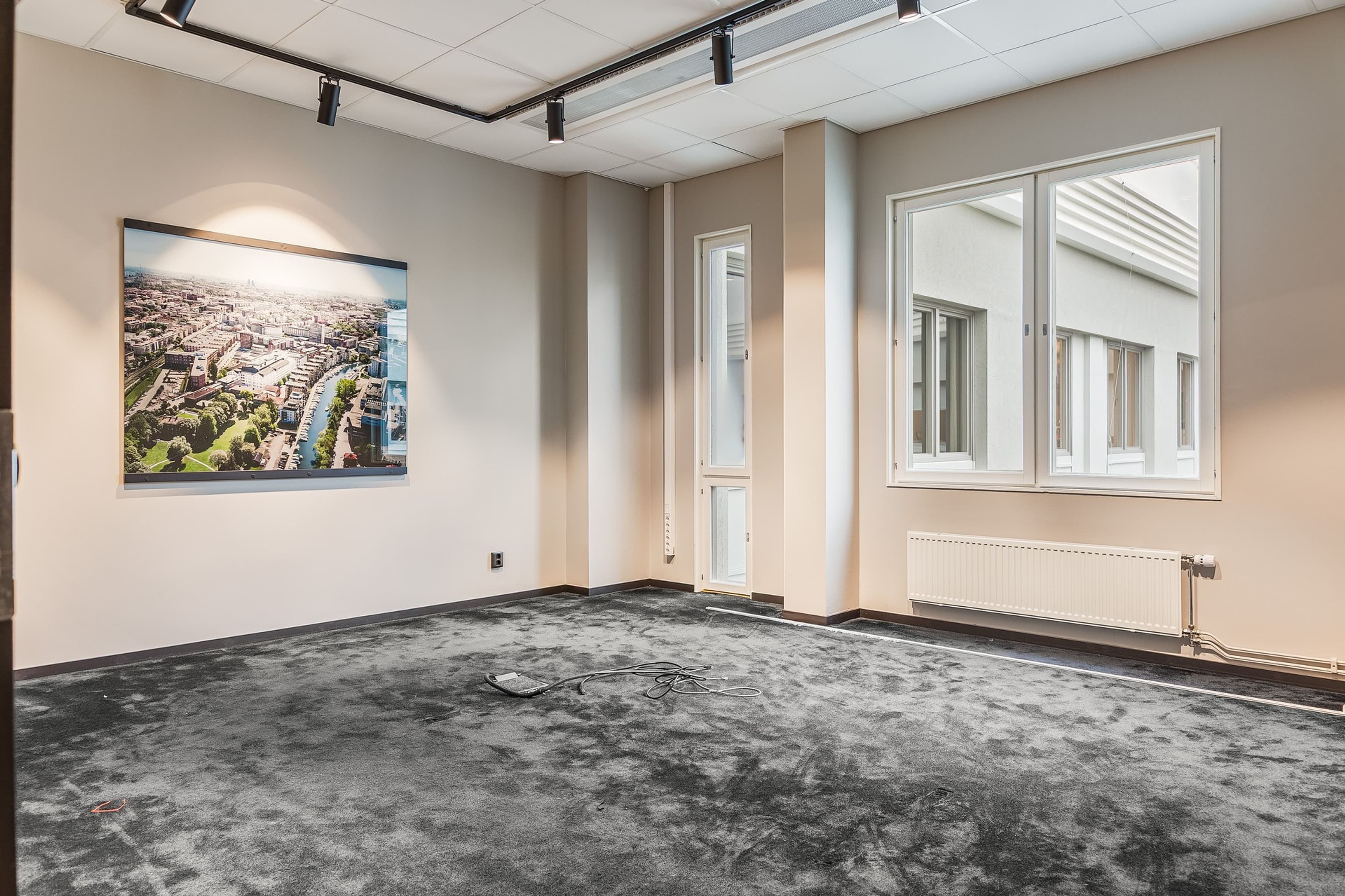 Ett tomt rum med en målning på väggen.