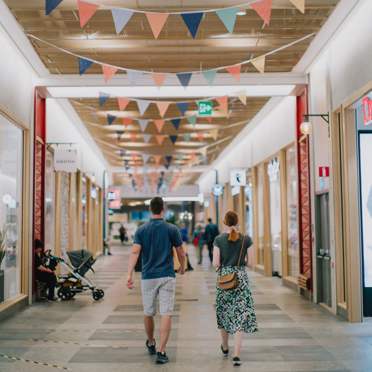 Några personer som går längs en korridor.