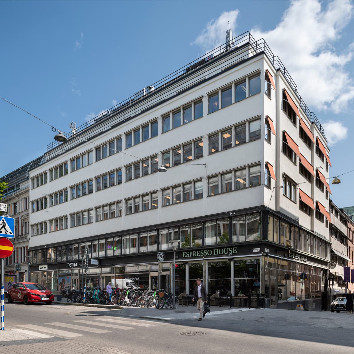 En stor vit byggnad som står vid sidan av en väg.