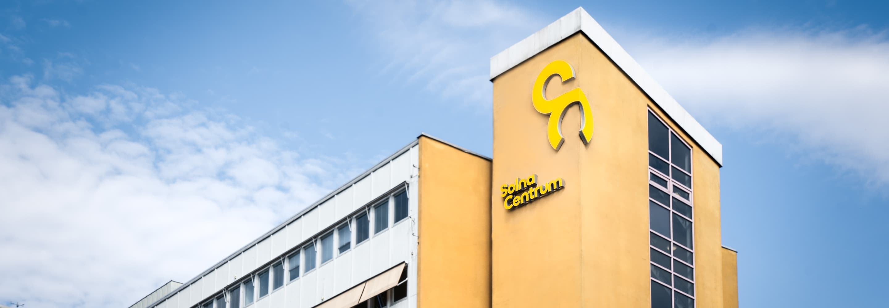 En stor byggnad med en gul och svart logotyp på.