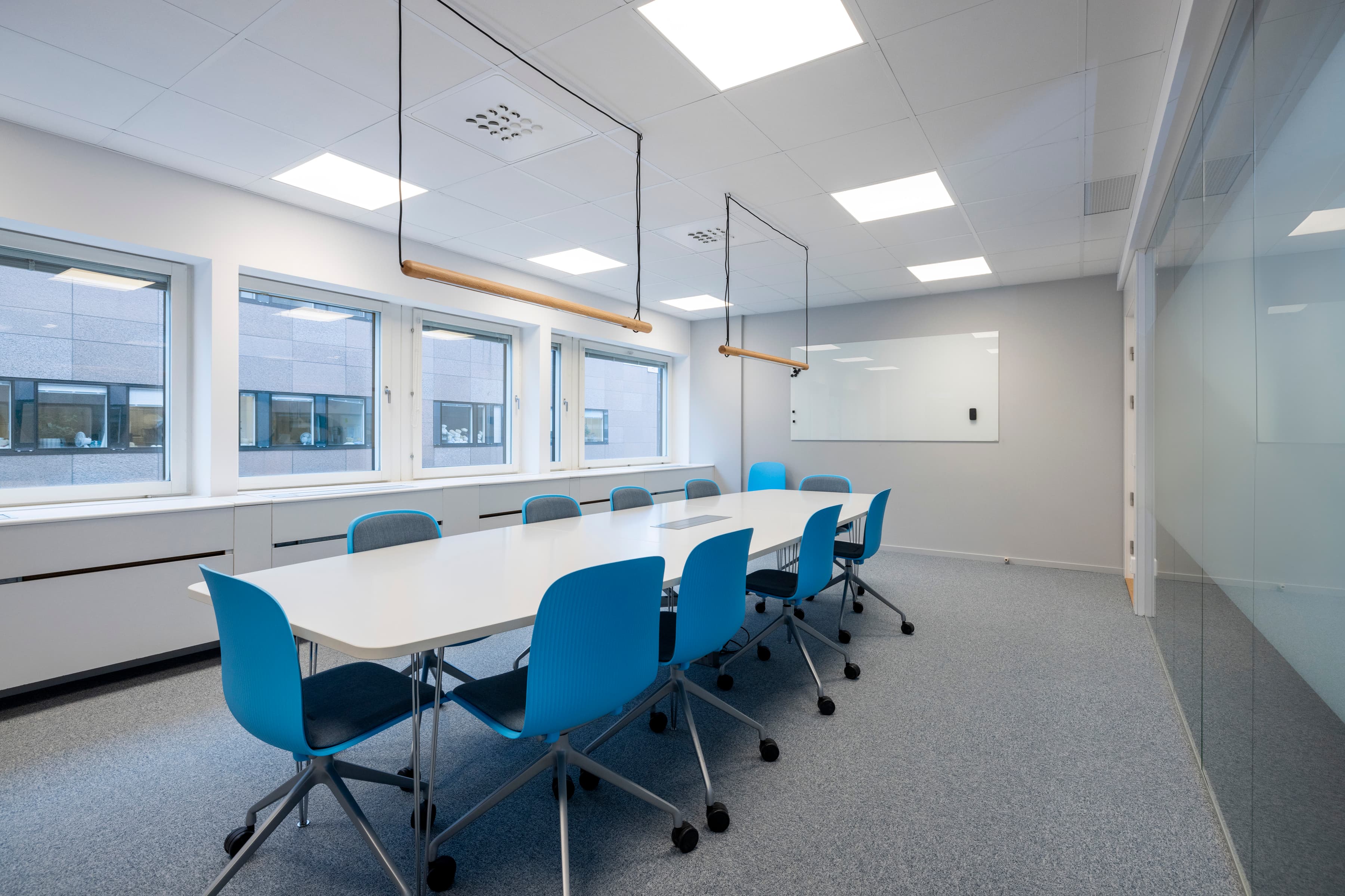 Ett konferensrum med ett långt bord och blå stolar.