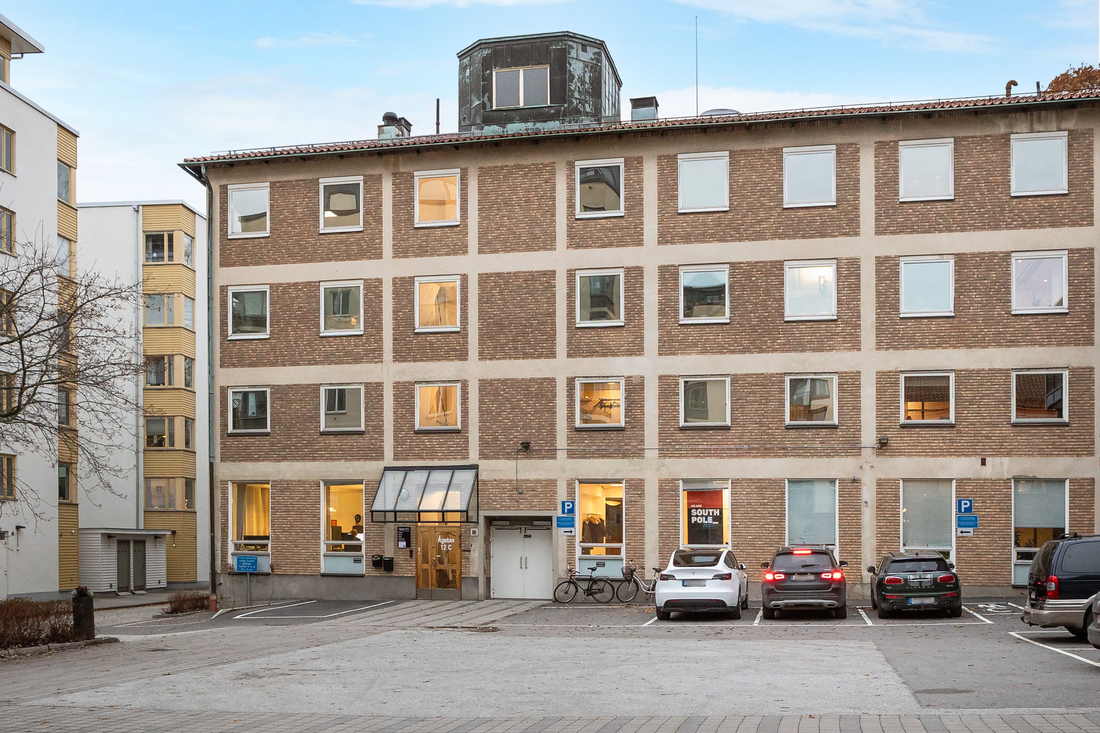 En parkeringsplats med bilar parkerade framför en byggnad.