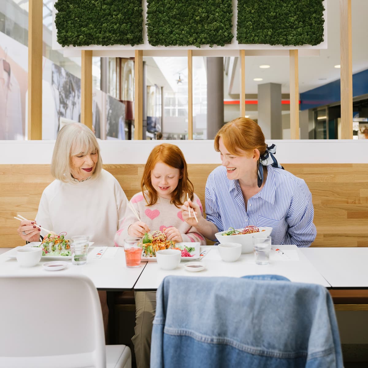 En grupp människor som sitter vid ett bord och äter mat.