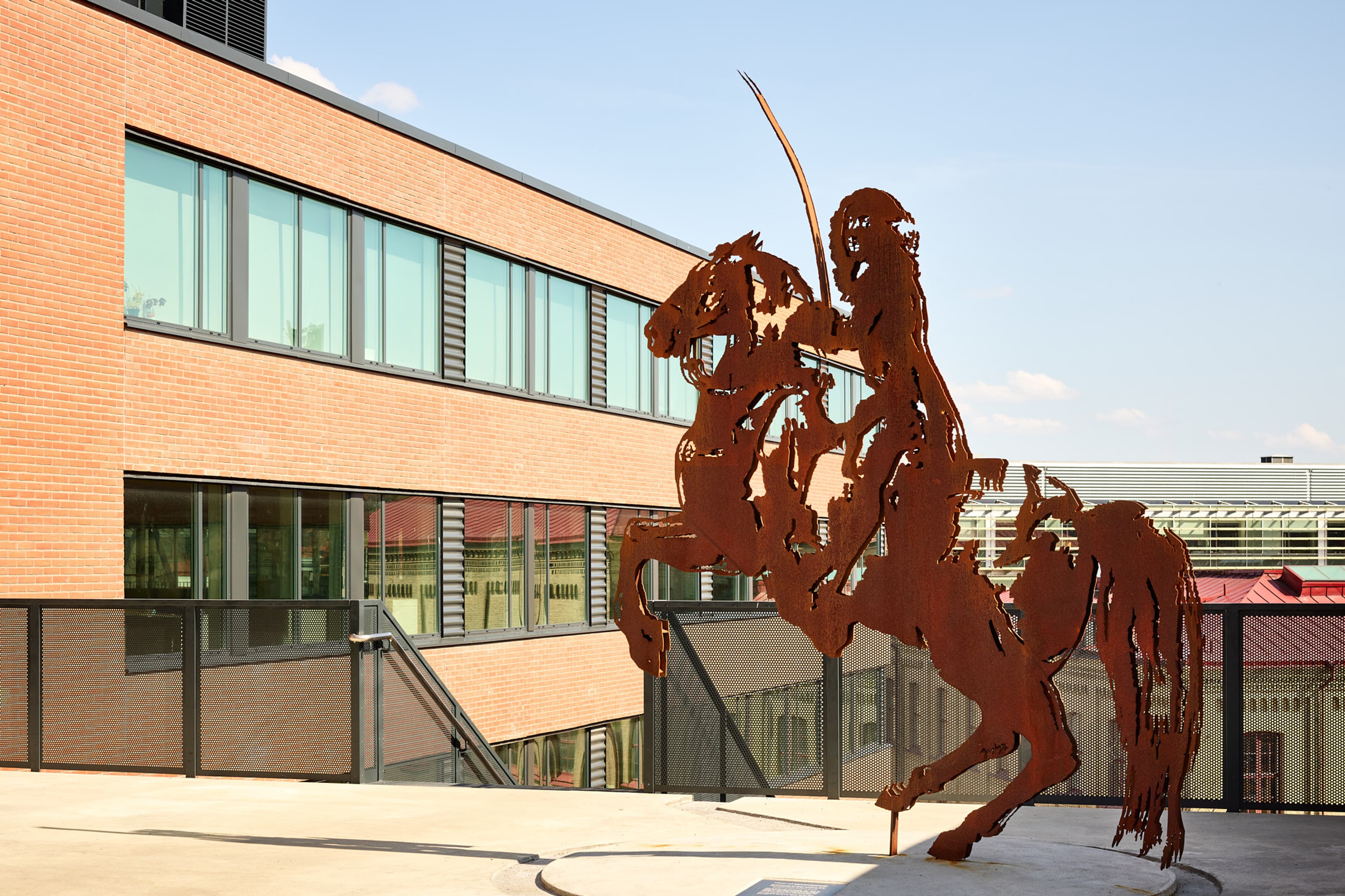 En staty av en man på en häst framför en byggnad.