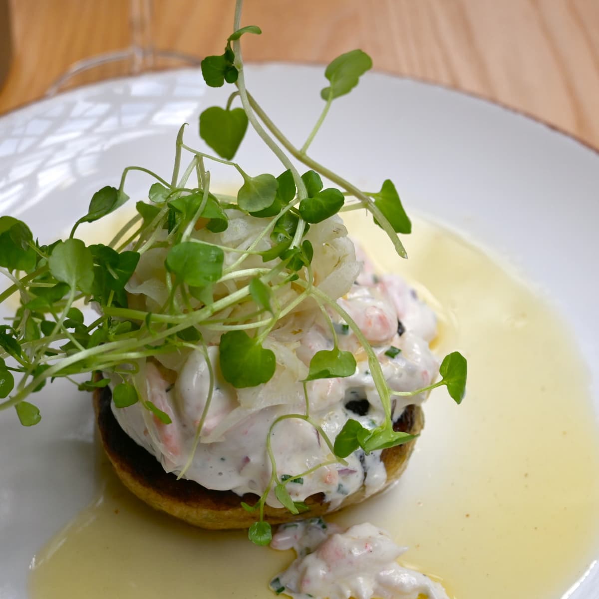 En tallrik med mat på ett träbord.