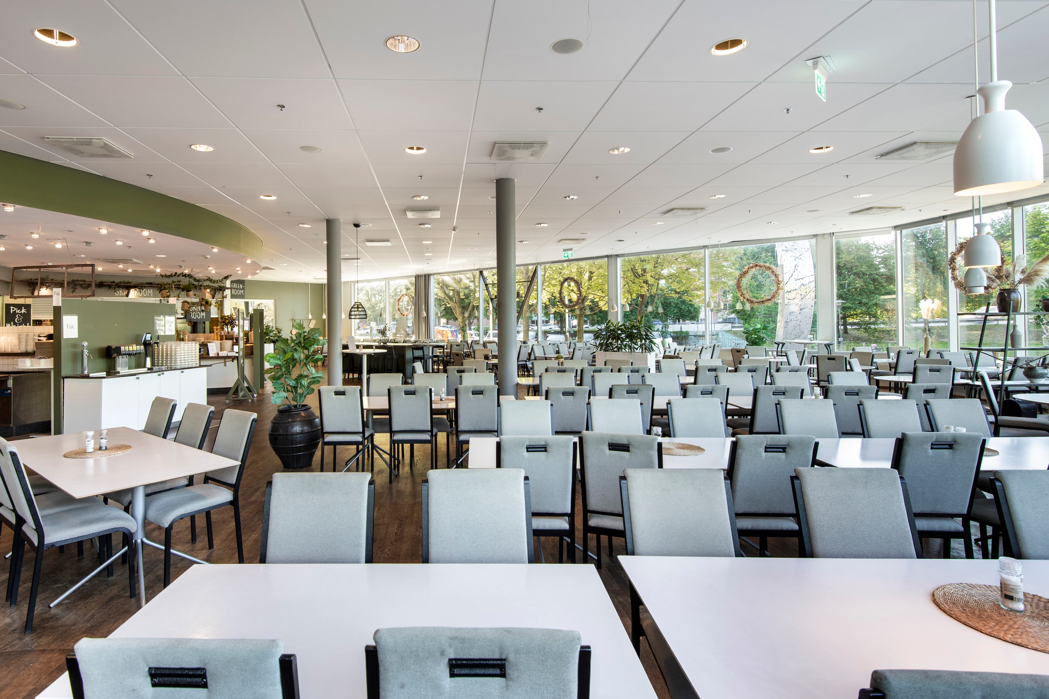 En restaurang fylld med många bord och stolar.