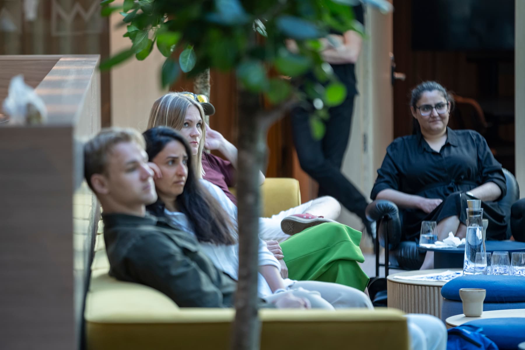 En grupp människor som sitter tillsammans i ett vardagsrum.