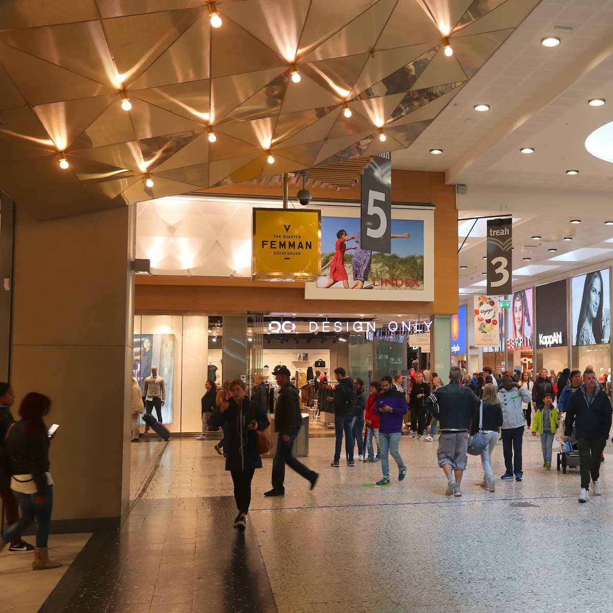 En grupp människor som går genom ett köpcentrum.