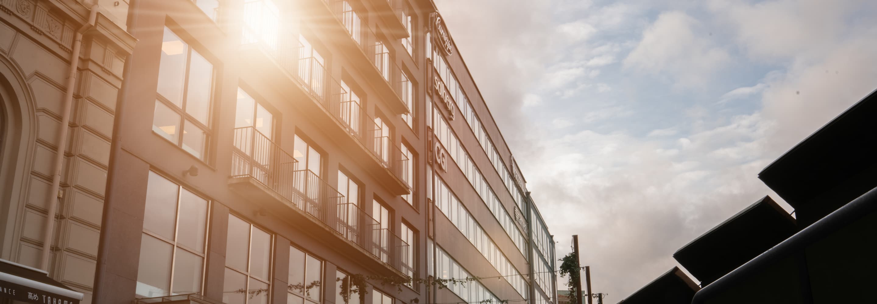 En man som går längs en gata bredvid en hög byggnad.